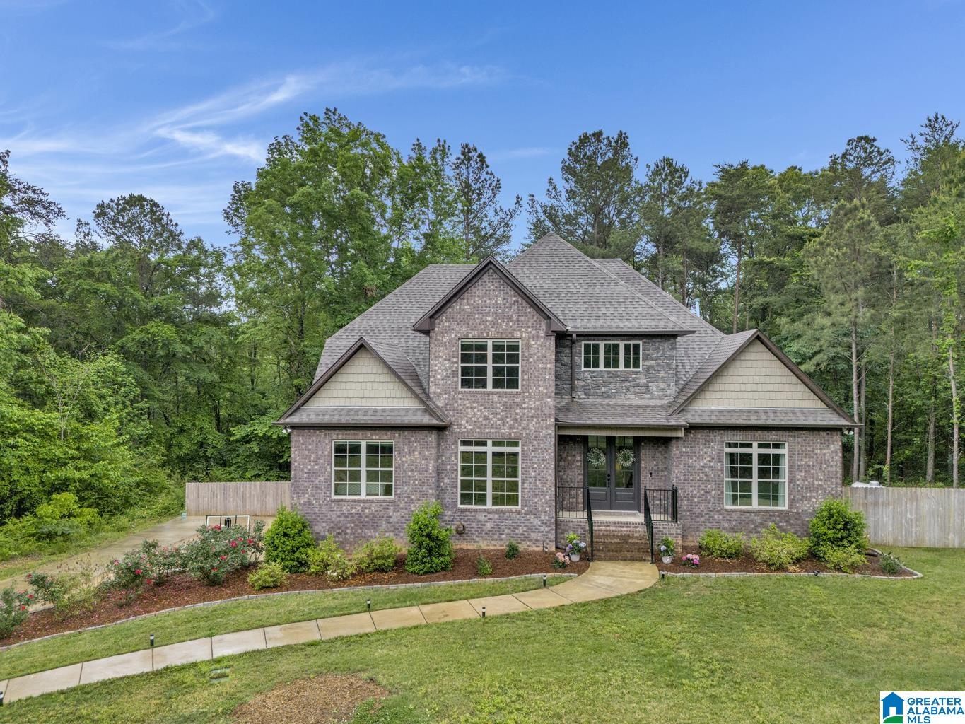 This 2022-built retreat, perfectly situated on 3+ serene/usable acres is a beautifully crafted home & offers a blend of style, comfort & thoughtful design. Step inside to find rich hardwood floors & open-concept living centered around a stunning kitchen—with stone countertops, custom cabinetry, a contrasting accent island, gas range, wall ovens & an upgraded refrigerator w/interchangeable panels. The living room invites relaxation with a cozy fireplace & access to extended covered & open decks—ideal for entertaining or unwinding. The main level includes a plush primary suite with a spa-like bath, offering a luxurious escape at the end of the day, along with a well-appointed guest suite. Upstairs, 2 additional bedrooms, Jack/Jill bath & a versatile den provide flexible space to fit your lifestyle. The unfinished walkout basement is currently a home gym & includes a 2-seat sauna to remain. A spacious 3-car garage completes this beautiful property.  Just 10 min to I65 & Timberline Golf.
