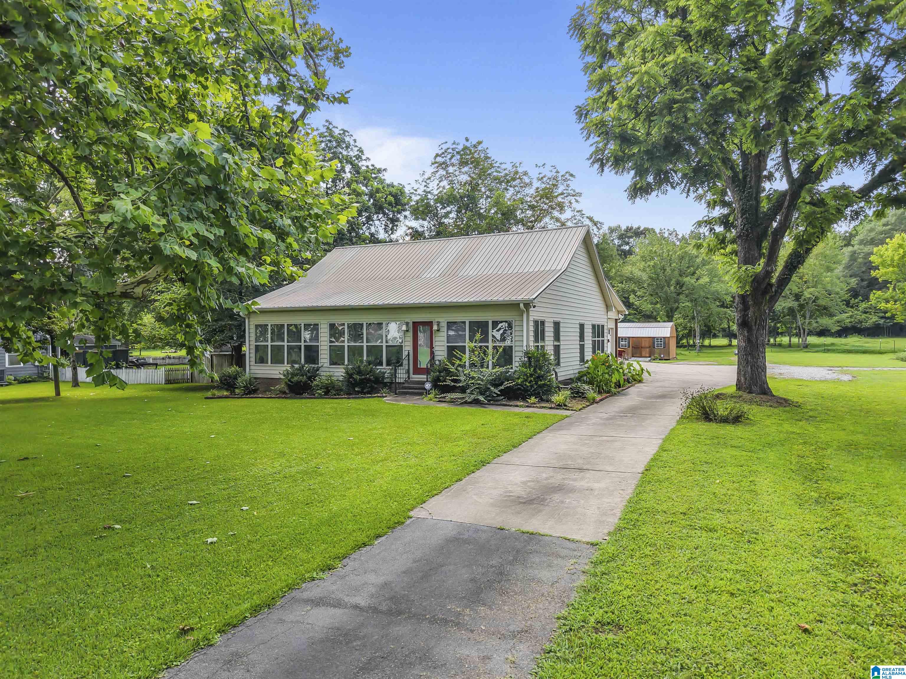 Well-maintained home in historic Palmerdale Homestead. Built in 2010 on a flat 3-acre lot with lots of potential. One-level living with 1,672 sq ft, crown molding throughout, solid surface counters, and bamboo flooring in the master. Heated and cooled glassed-in front porch offers year-round use. Key features include encapsulated crawlspace, whole-house surge protection, new HVAC and leaf gutter guards. Washer, dryer, and freezer remain. Oversized laundry room and two-car garage provide extra space and storage. Property includes two mature Sycamore trees and a rare Japanese Black Walnut, all approx. 100 years old. Located minutes from Hwy 75 with easy access to Pinson schools, shopping, and dining. Quiet, established neighborhood with no HOA. Ideal for those seeking space, privacy, and convenience. Plenty of room to build a shop, garden, pool, or even add another home.