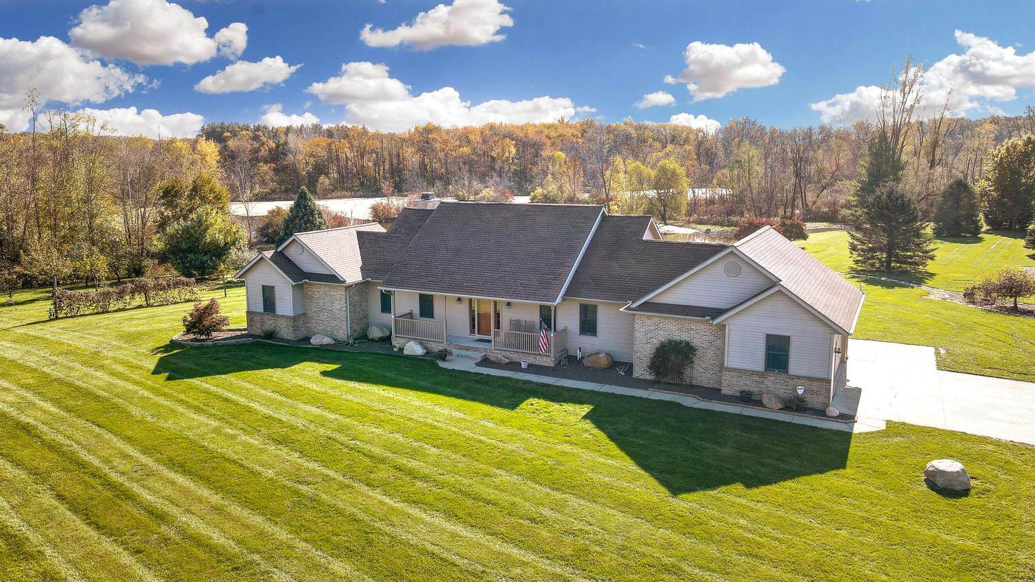 An exceptionally beautiful and rural homestead situated on 20 acres of country paradise. The perfect oasis with an abundance of wildlife + private pond. This custom built, spacious ranch home with walkout basement offers over 2,900 finished sq. ft. plus a spacious 17x17 wine cellar! Welcomed by excellent curb appeal and a covered front porch. As you enter into the front foyer you’ll find hardwood floors leading you into the formal living room to the left side & formal dining to the right. Just down the hall a powder room, spacious kitchen open to the breakfast area and family room. Any home chef will appreciate the ample cabinet space, built in pantry & uninterrupted views of nature’s paradise in your own back yard! With breakfast bar, adjacent dining space, access to the backyard deck and open to the family room boasting plenty of natural light, vaulted ceilings, fireplace, access to the backyard & additional views of the surrounding acreage. Just around the corner is the grand master suite with trey ceilings, walk in closet, private en-suite & personal access to the backyard deck and yard. At the lower level, you can unwind in the walkout den with private full size bar made from harvested cherry wood from the homestead & oversized wine cellar! Two additional bedrooms located at the basement level with full bath & mechanical room with storage space. Outside amenities include gas hook up at the deck, two large out buildings, one of which is finished with office space and full bath. A nature lover’s paradise- this property has a fully stocked pond along with four acres of active and thriving wetlands. Woods at the back of the home are perfect for hunting and the property hosts a large asparagus field, mature fruit trees and shooting range. Additional amenities include two year roof, newer geothermal unit, main floor laundry and more!
