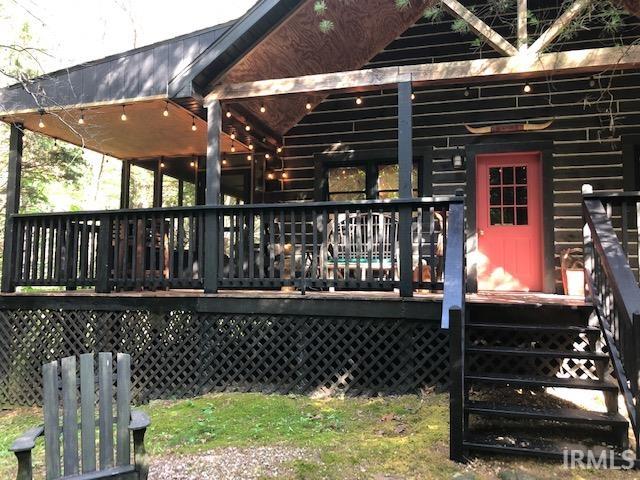 Let's take a look at this cabin tucked in a Cedar and hardwood tree grove.  Not lake side but 25 minute hike to the shoreline thru DNR forest. 10 minute drive to beach/ marina. Patoka Forest wildlife roam outside your elevated screen porch. Down on the ground enjoy the outdoor fire pit area. Best of all, this home is fully furnished and ready for you to pack your bag, bring groceries and enjoy cooking in this equipped kitchen and outside grilling patio.  Are you Ready now to satisfy your dreams of owning a cabin in the woods? Best of all, it's very close to Patoka Lake water activities. When you finish a day on the lake come home to this;  covered open front deck, fire pit or screen porch and relax in this 2 Bedroom,  2 full bath comfortable cabin on two levels with bed and bath on each level for    added privacy.  Your dream has come true!!  Need I tell you more.......  This get-a-way is nestled on a one acre lot down a single private lane. Not visible from the road. This rural development of log cabin homes adjoins the DNR  forest property.  Yet this is only a few minutes away from restaurants, winery, convenient store, marina, beach and boat launching ramps. The eat in equipped kitchen has GE Profile platinum finish appliances and banquet style dining table.  Stack washer dryer in closet. Slate tile bath floors and easy to clean fiberglass tub shower plus a second walk in shower. Central heat and air and climate controlled crawlspace.   Only a short drive, maybe 3 minutes to the winery and restaurants, 7-10 minutes to the closest marina. This lot has space for a garage if you want to stow a boat.