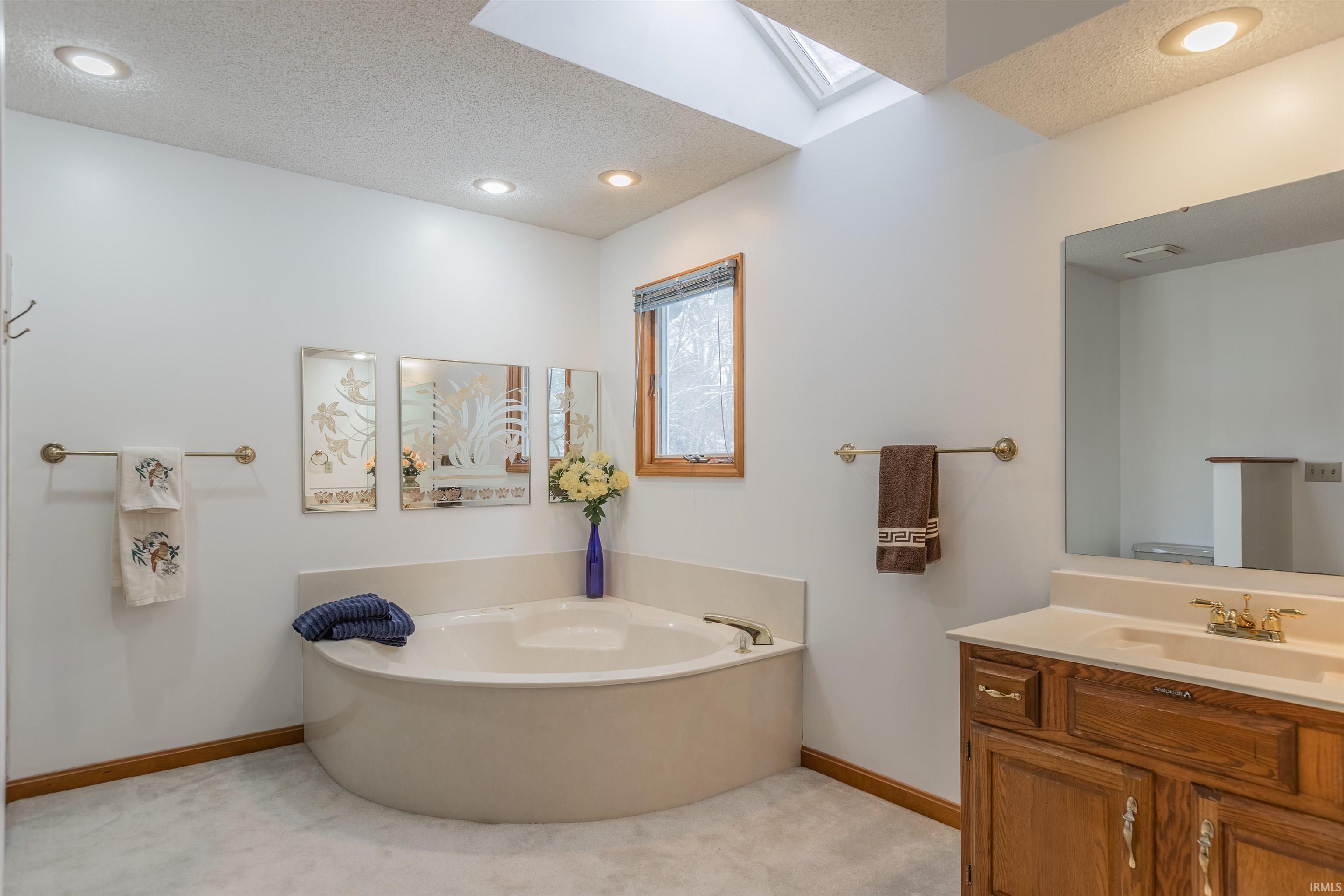 ...with Separate Step-In Shower, Skylight, Dual Vanity, Linen Closet, Mirrored Medicine Cabinet, and Jetted Tub