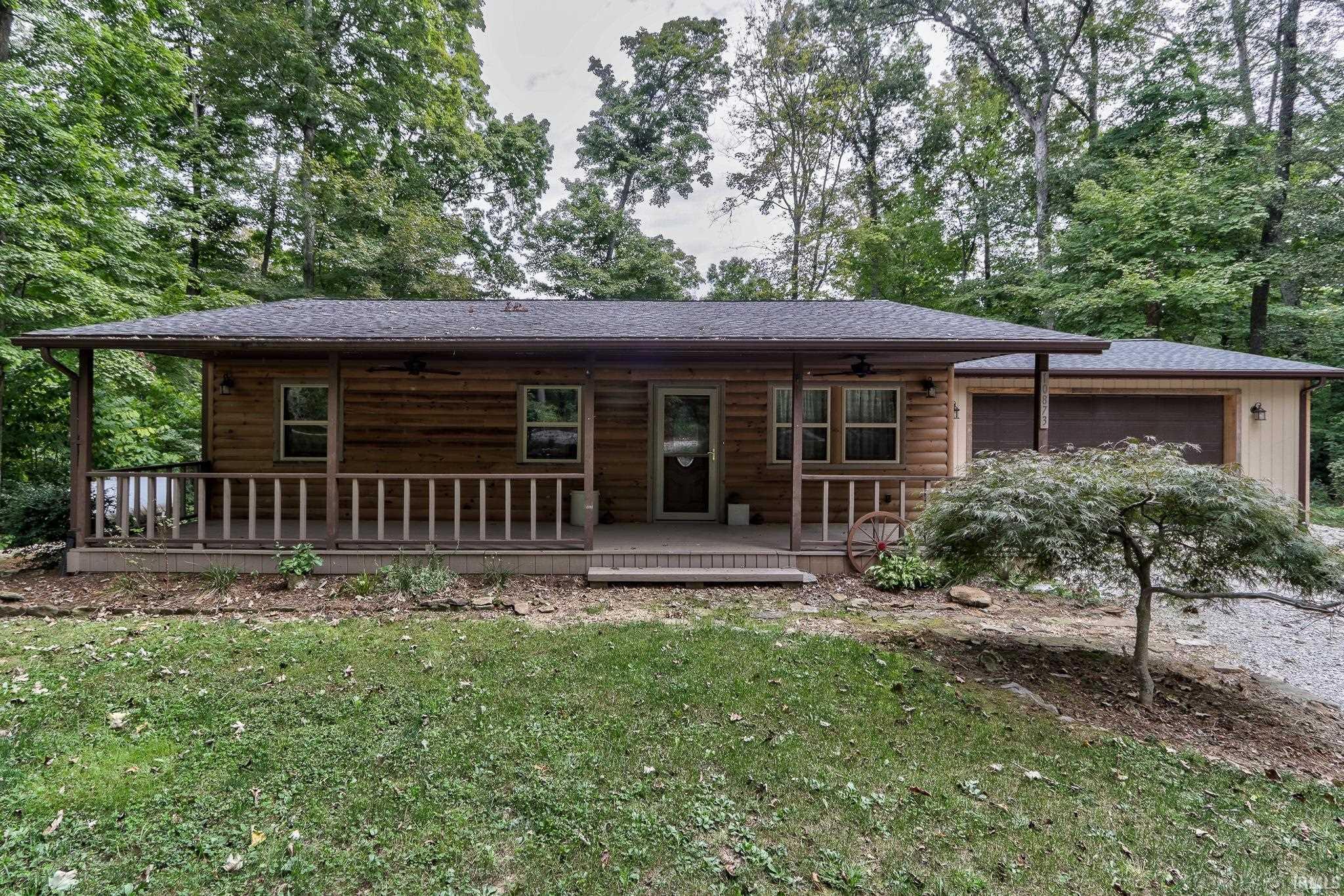 Enjoy lake living with this completely remodeled 3 bedroom, 1.5 bathroom home in Lake Helmerich Village! Don't miss out on your chance to own a home located on 4 lots, totaling over 6 acres of wooded land in a peaceful and quiet setting.  As you approach the home, you're greeted by the welcoming front porch, which is the perfect place to drink your morning coffee. As you enter the home, you'll find a living room with plenty of natural light that flows into the updated kitchen. The eat-in kitchen features updated stainless steel appliances, beautiful painted cabinets, updated countertops, and original hardwood flooring. The spacious primary bedroom has the hardwood flooring and a private half bathroom that has an updated light fixture, vanity and toilet. There are two additional bedrooms that have hardwood flooring and updated ceiling fans. The full bathroom has a beautiful, updated vanity, light fixture, and toilet. You'll fall in love with the outdoor space when you visit this property! Attached 2 car garage, additional detached 1 car garage, AND a pole barn for all of the storage you could need! Updates include lighting, countertops, appliances, fresh paint, carpet, garage roof, windows, landscaping, and much more.