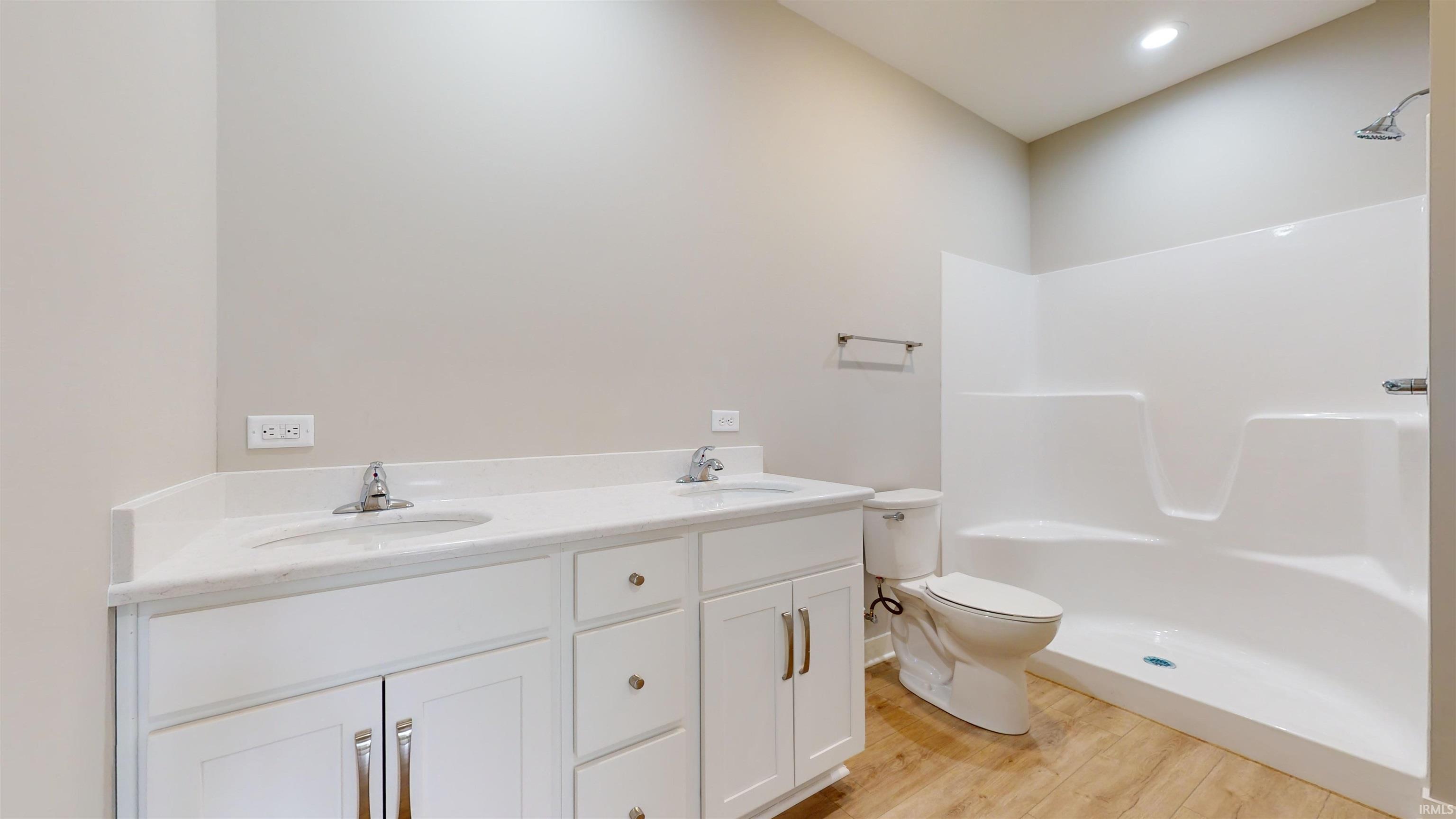 Features a walk-in-closet with custom wood shelving, a step-in shower, & a double vanity.