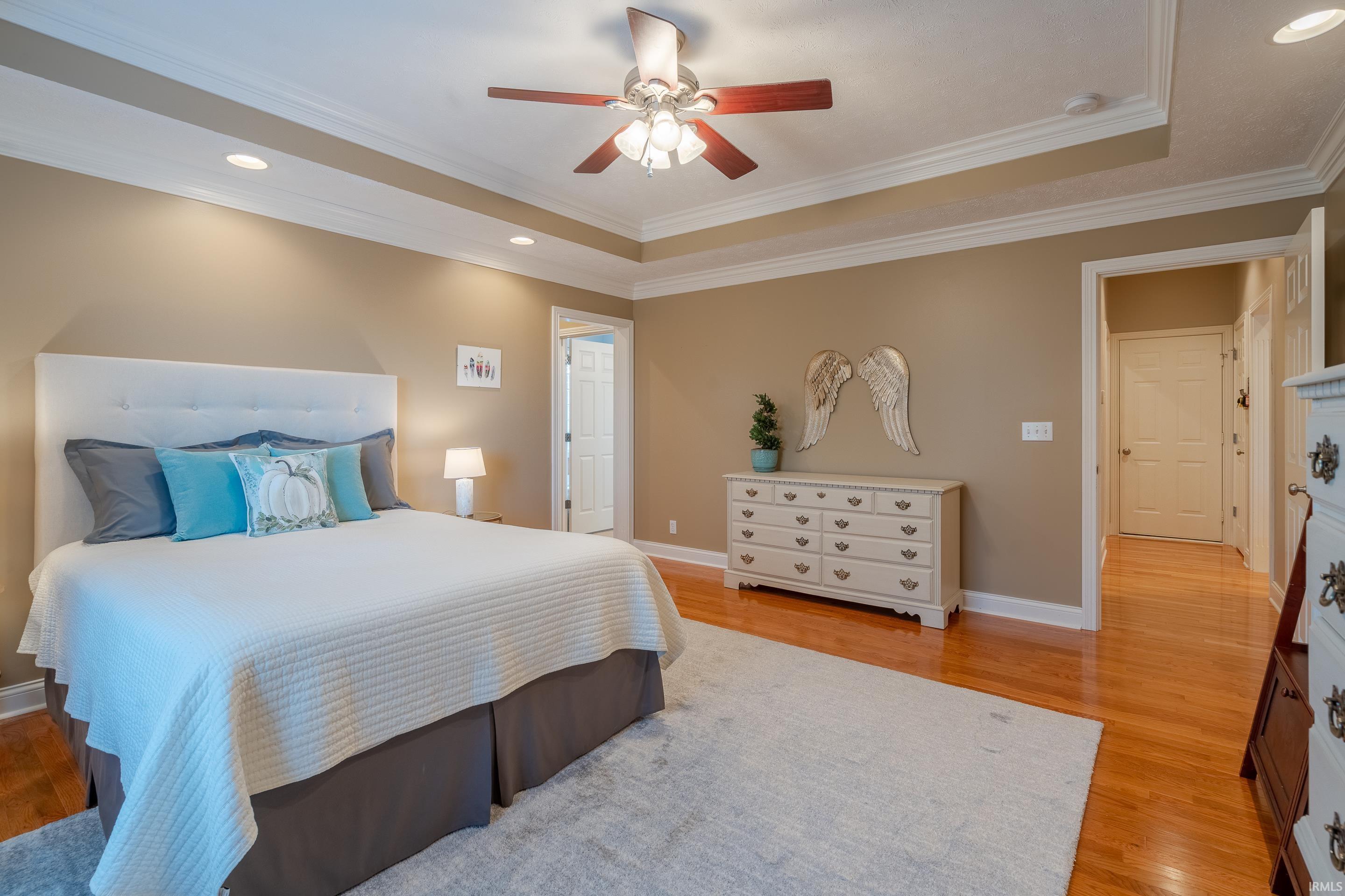 Trey ceiling and crown molding accent primary bedroom.
