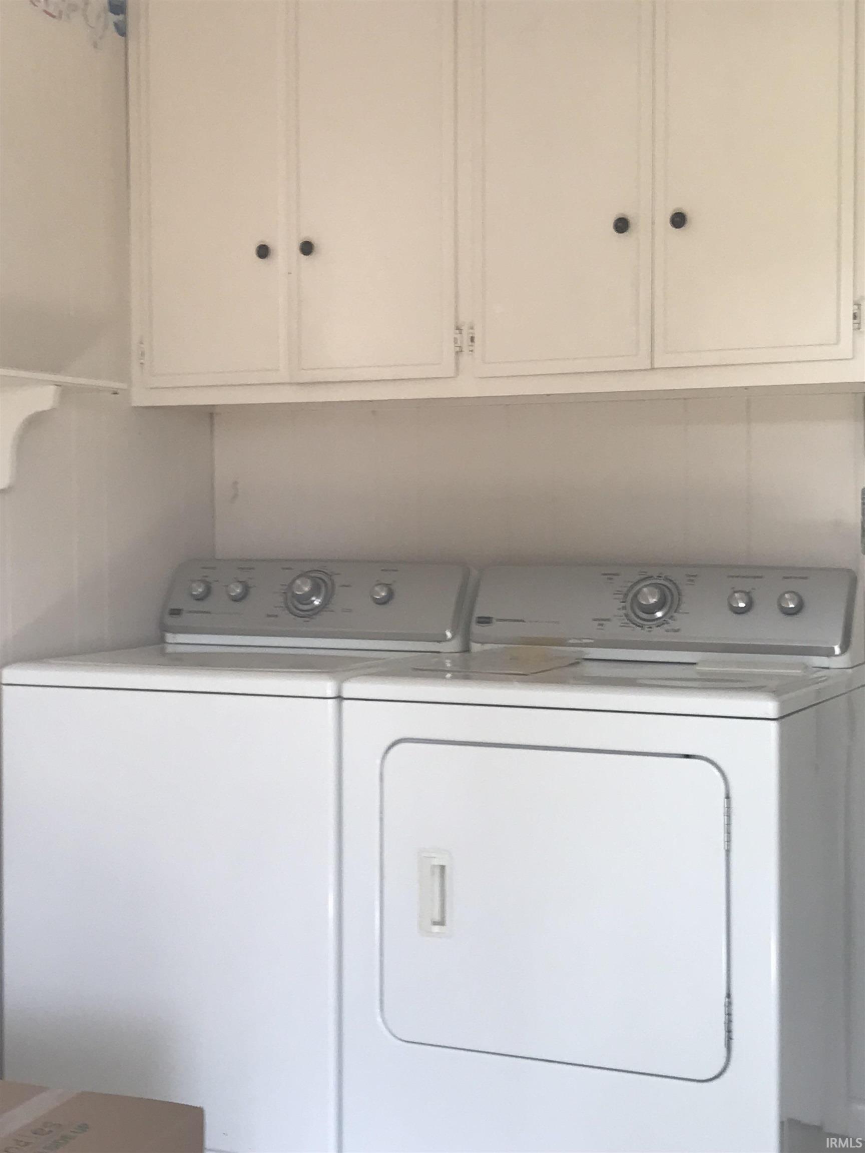 Washer, dryer, cabinets on wall, water softner