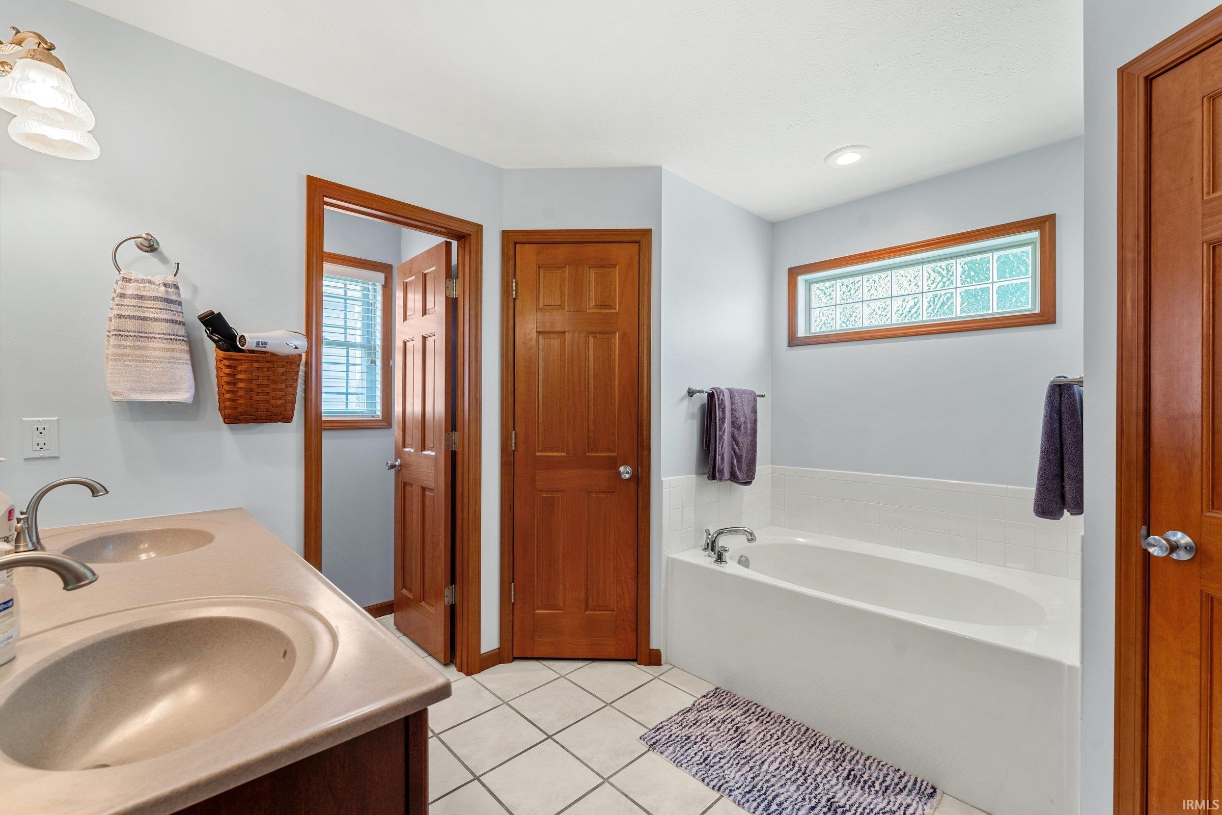 This bathroom includes his and hers walk-in closets.