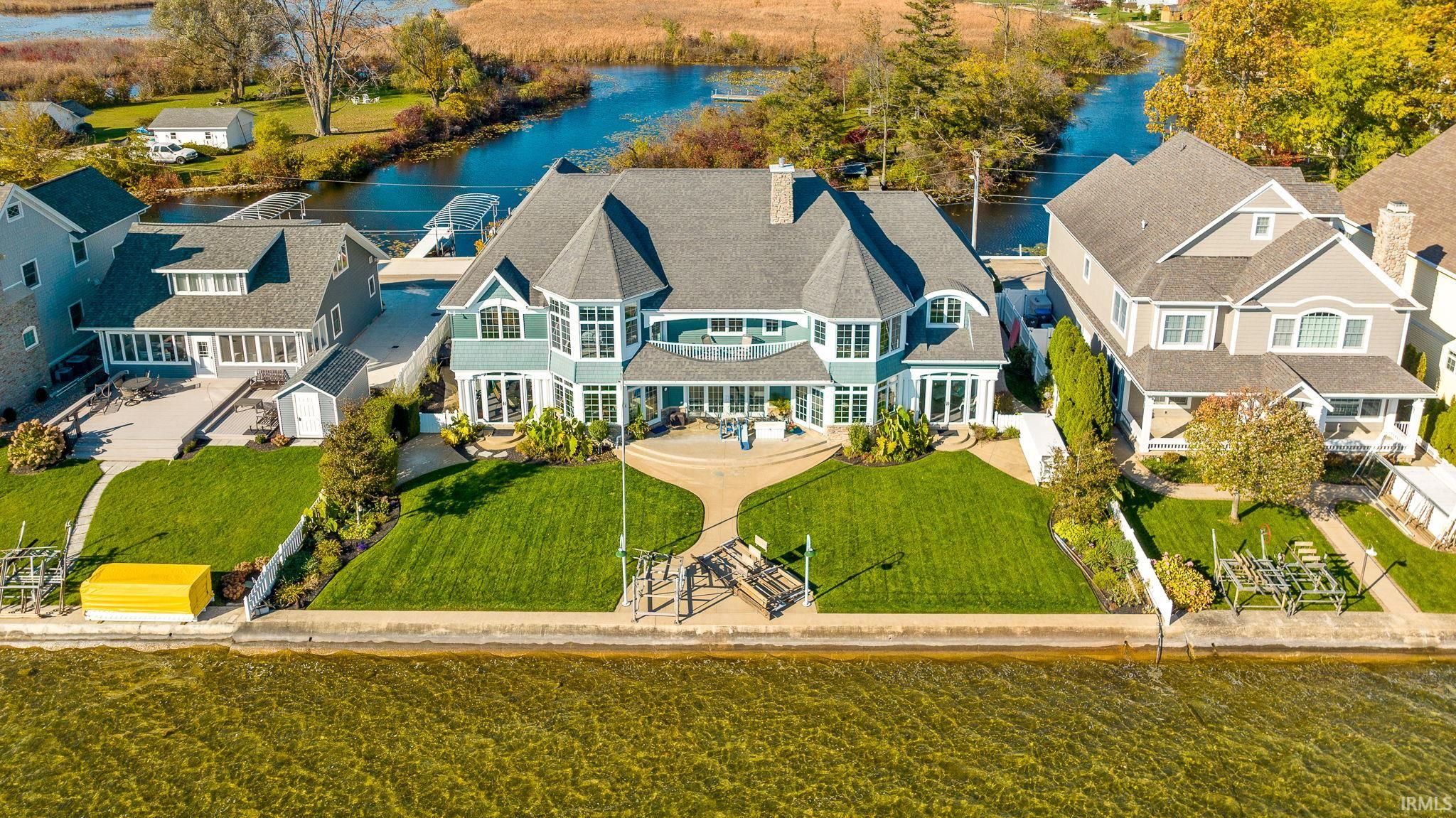 Welcome to this luxury residence set on Kale Island, nestled amidst the shimmering waters of Lake Wawasee, Syracuse, IN. Offering an impressive six Bedrooms, all with views of the water including Two Master Bedrooms with incredible Ensuite Bathrooms. This marvelous home also offers four full Bathrooms, and two sophisticated powder rooms. As you approach the private drive, a serene atmosphere welcomes you. This masterpiece is a TL Jackson built home on a double lot! With 100 feet of pristine lakefront and an additional 100 feet of channel frontage you can enjoy breathtaking views from every angle. With a sandy bottom lake bed, you can walk right in at the end of your pier!  The heart of this splendid home showcases a gourmet kitchen adorned with custom cherry cabinets that seamlessly blend with a rare blue granite countertop, an homage to the neighboring lake's hues. Crown molding enhances the property’s refined aesthetic of timeless elegance and modern comforts. Venture through the expansive living space where natural light dances off every surface and a fireplace surrounded by custom woodwork awaits you. On opposite sides of the residence, two magnificent screened in porches provide a harmonious balance of sunrise and sunset views each offering a unique vantage point to further enjoy the tranquil surroundings. The spacious three-car garage serves as both a haven for your prized vehicles and a testament to the property’s emphasis on functionality amidst luxury. Whether it’s the majestic water views, the meticulously crafted interiors, or the promise of serene lake living, this home beckons those with a penchant for the finer things in life. Dive into the epitome of lakeside luxury. Here on Kale Island, life isn't just lived; it's celebrated. Even with all the privacy this Estate offers, you are still only minutes from fine dining and shopping! Book your private viewing today and experience firsthand the magic of this Lake Wawasee jewel.