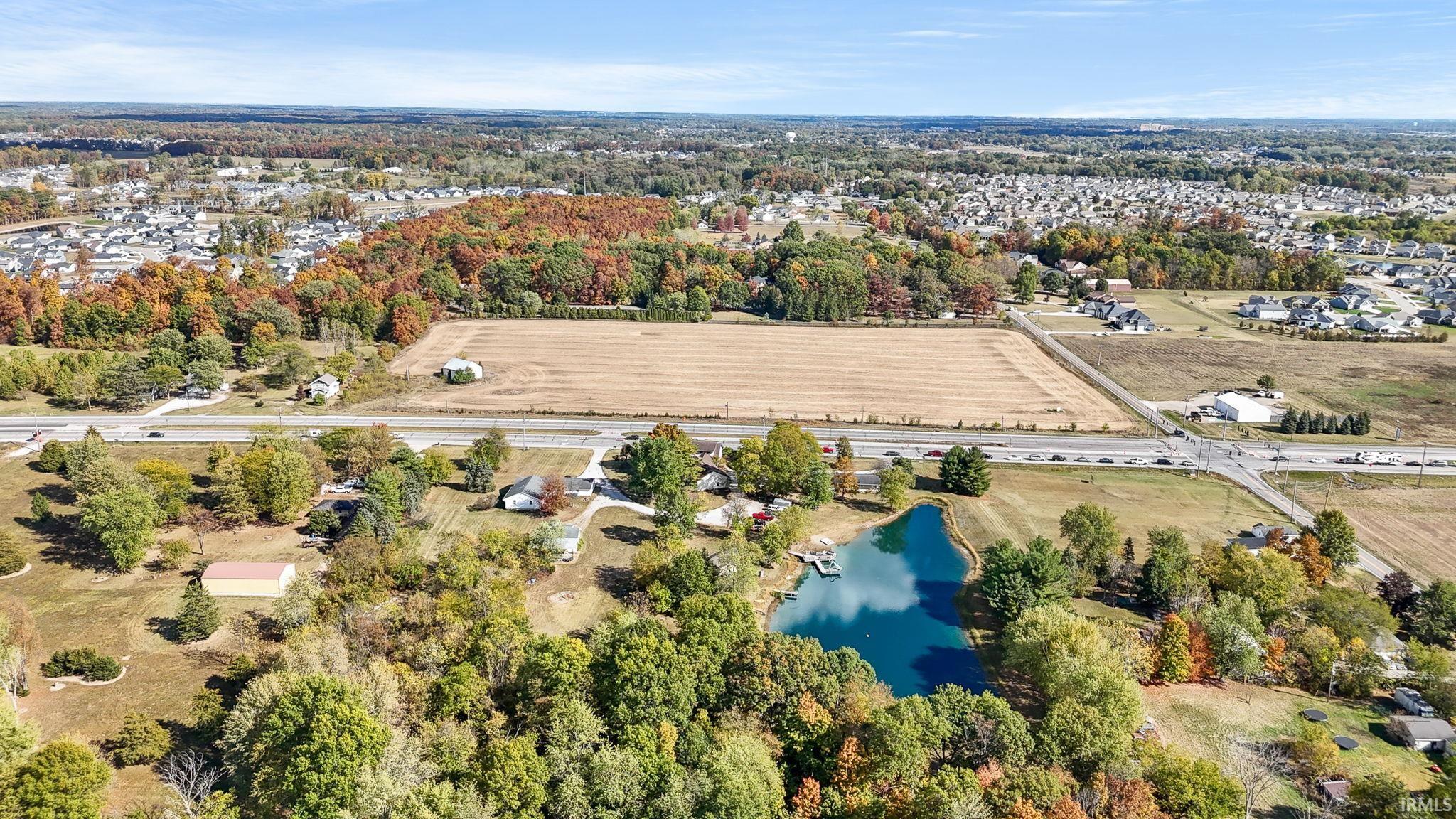 Aerial view of property and surrounding area featuring a large body of water and rural landscape