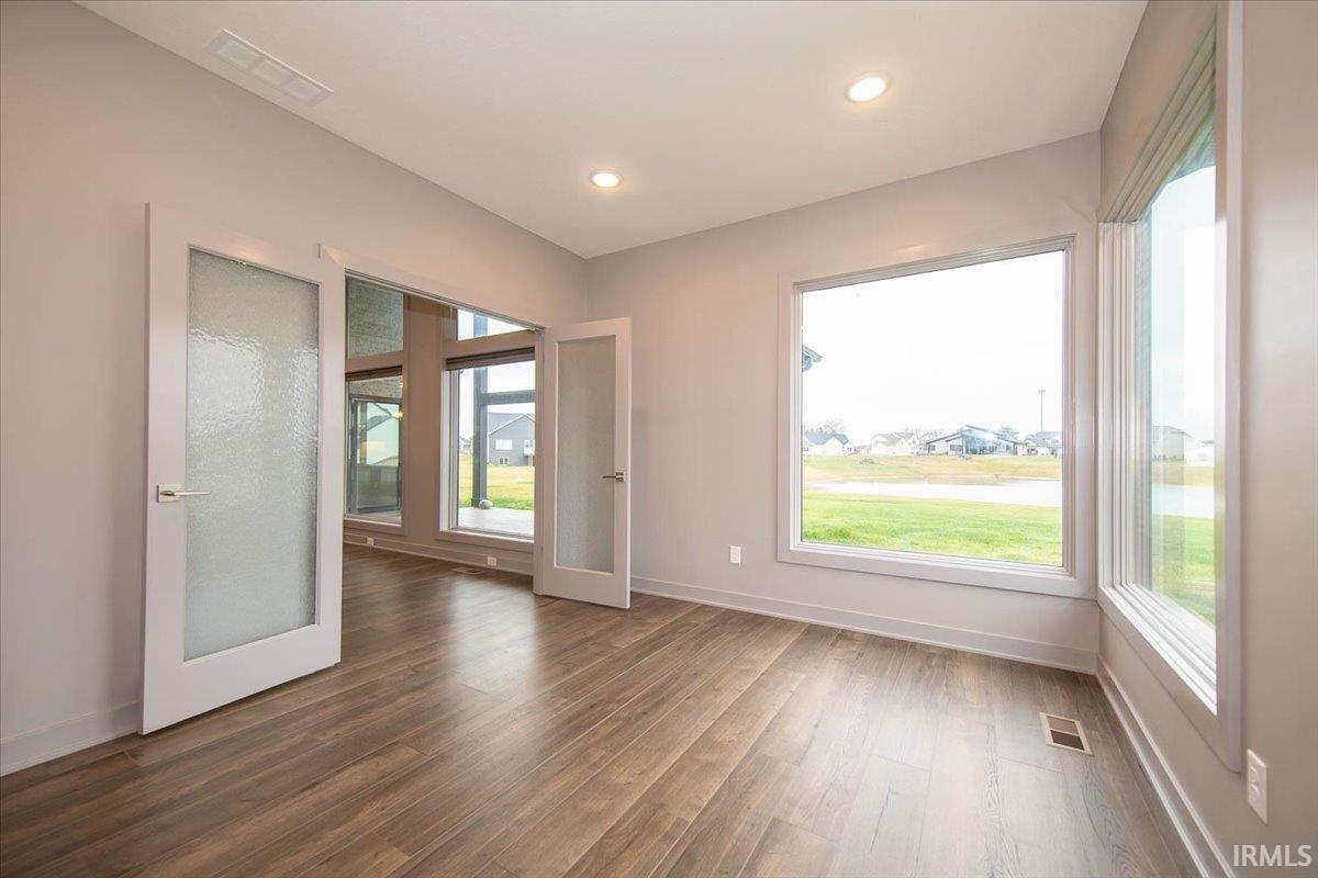 The Study has double doors accented with glass and both Windows have a view of the Pond.