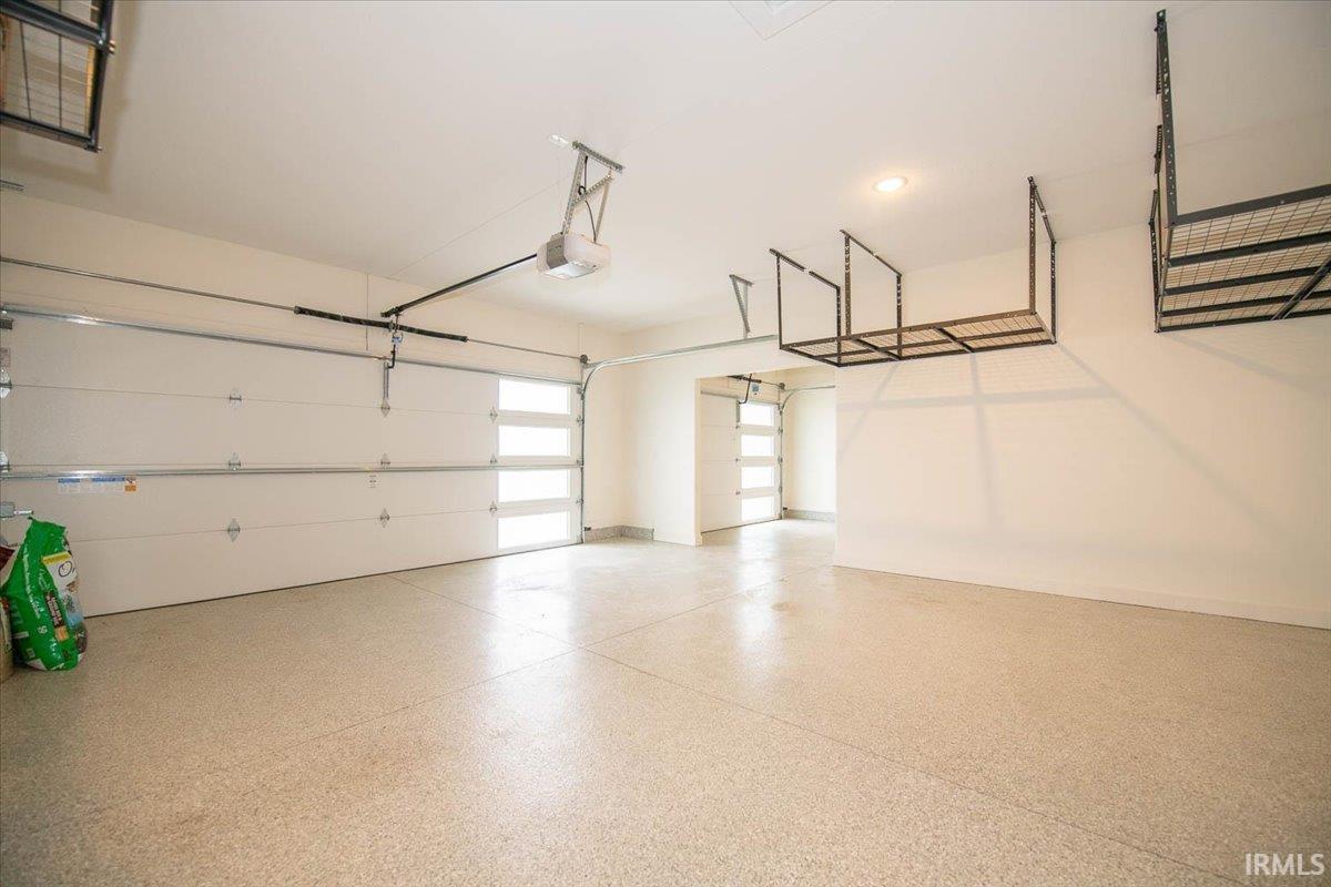 The 3 bay garage has non slip epoxy flooring. Notice the Overhead Storage Units. The third bay can be set up as a work shop complete with a 220 outlet
