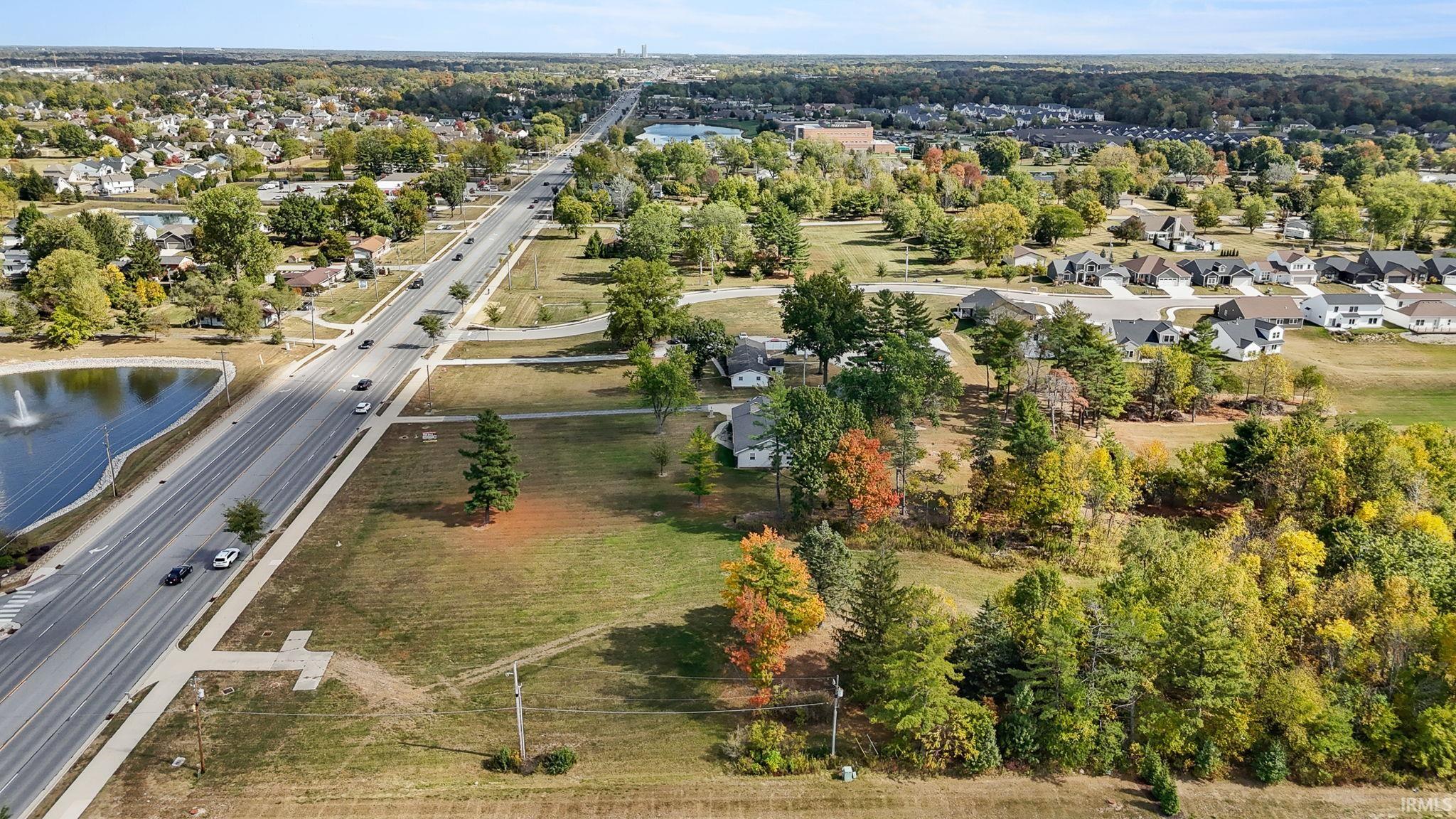 Aerial view of residential area with a major roadway and a tree filled landscape