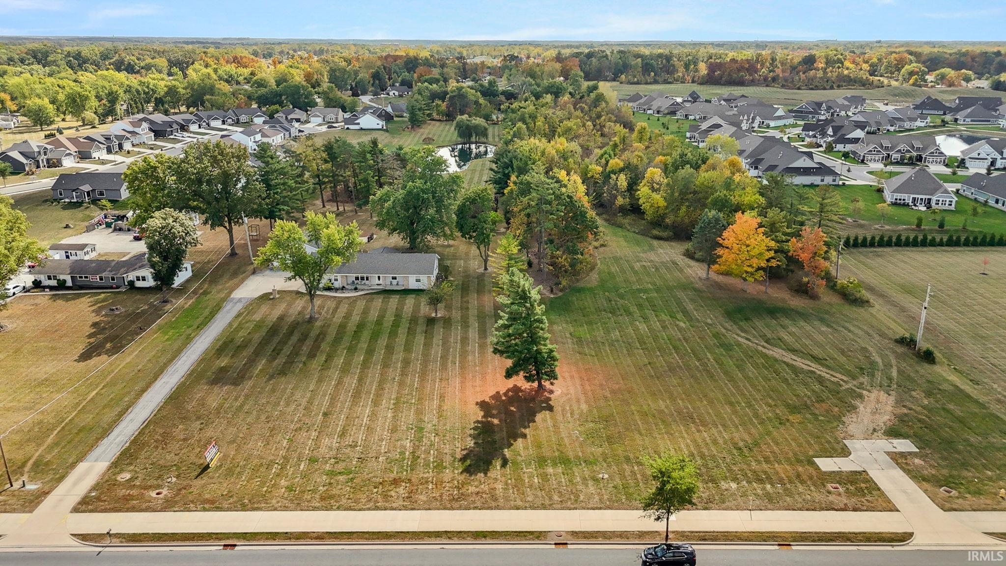 Aerial view of property and surrounding area featuring nearby suburban area