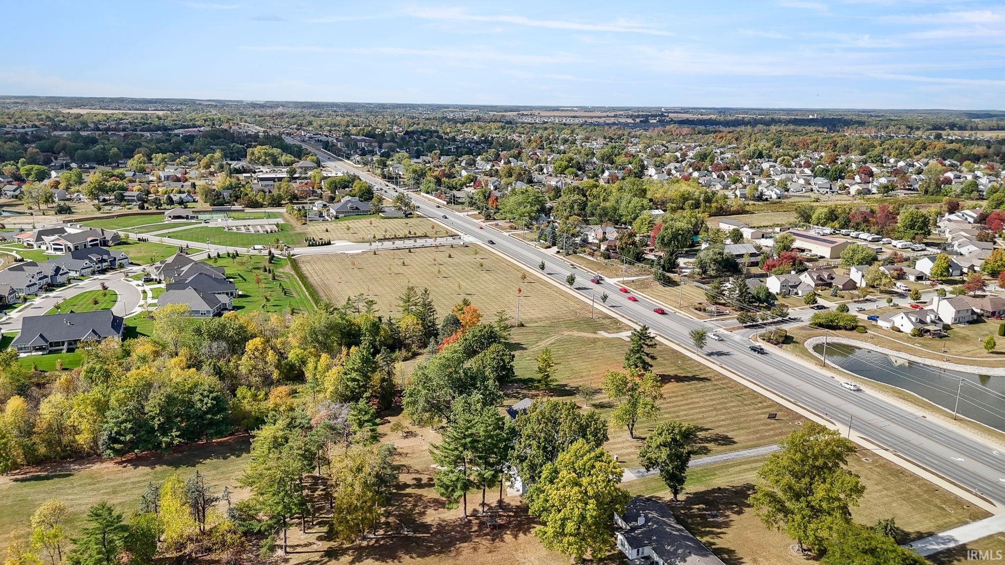 Aerial view of property and surrounding area featuring nearby suburban area