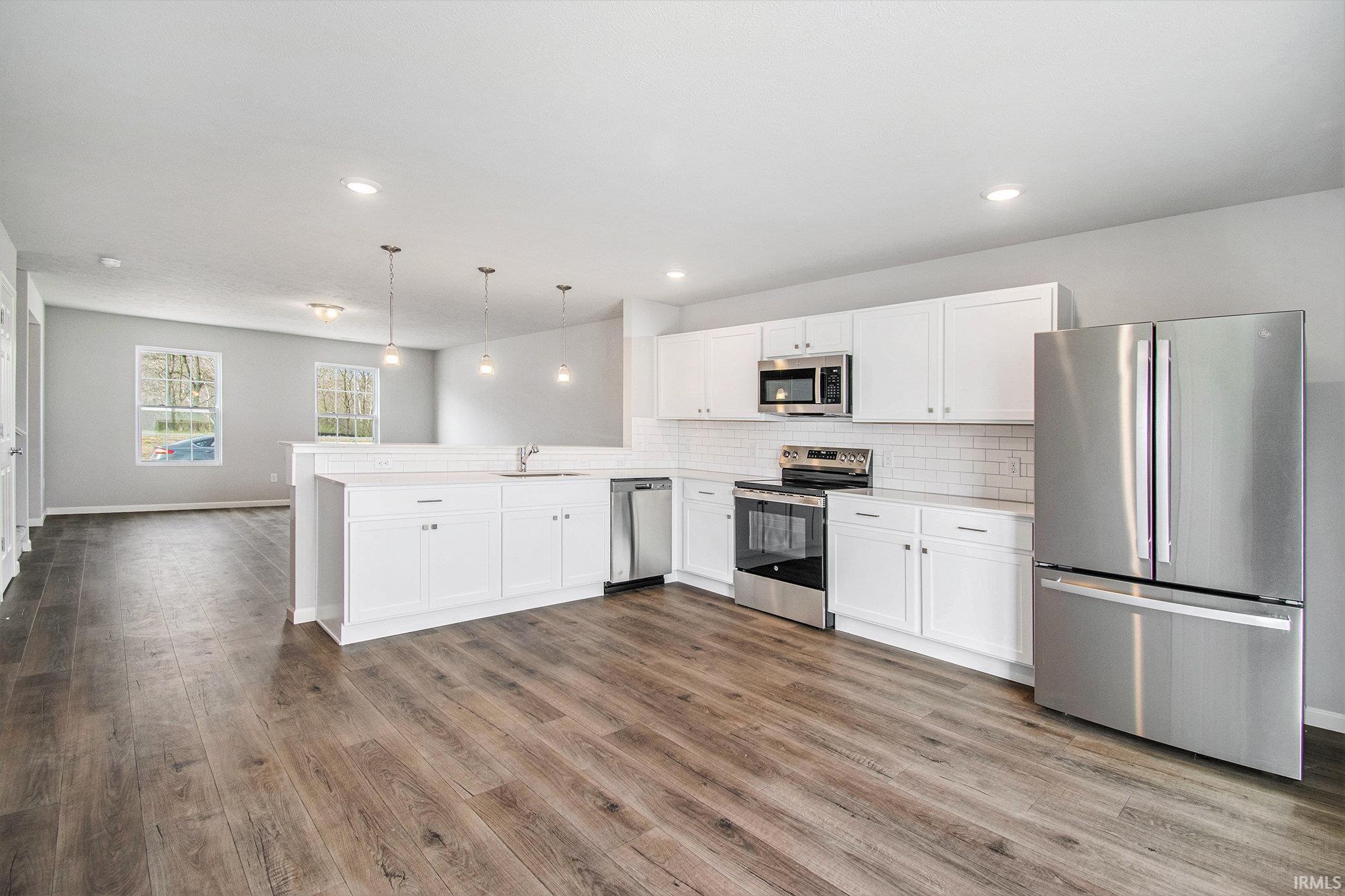 The great room flows into the kitchen, separated by breakfast bar that can accommodate bar stools with pendant lighting above. Kitchen & eat-in dining nook are an efficient use of space with quartz counters, subway tile backsplash, appliances included!