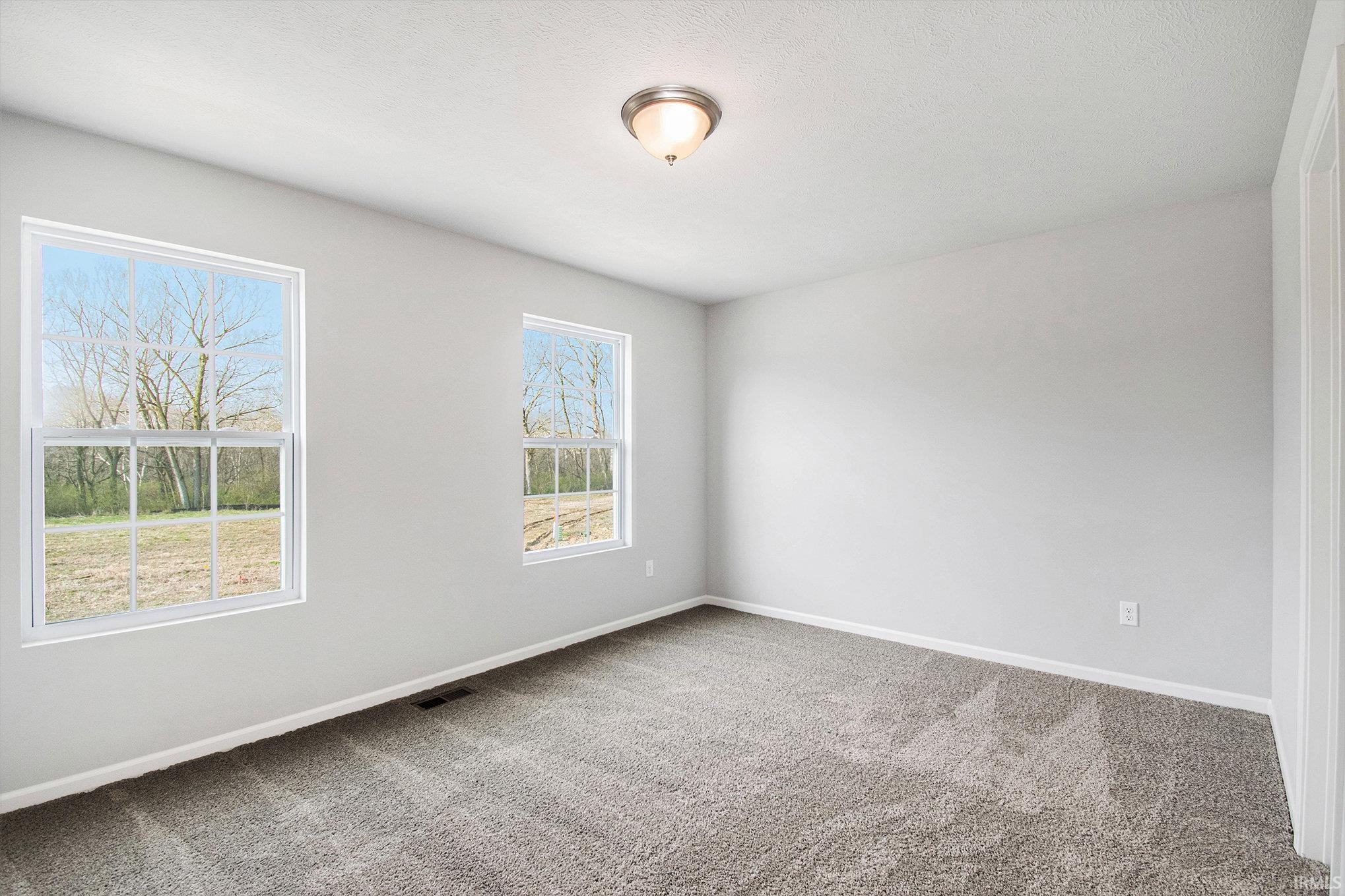 The primary suite features double exterior windows, a private bath with an exterior window and a large walk-in closet.