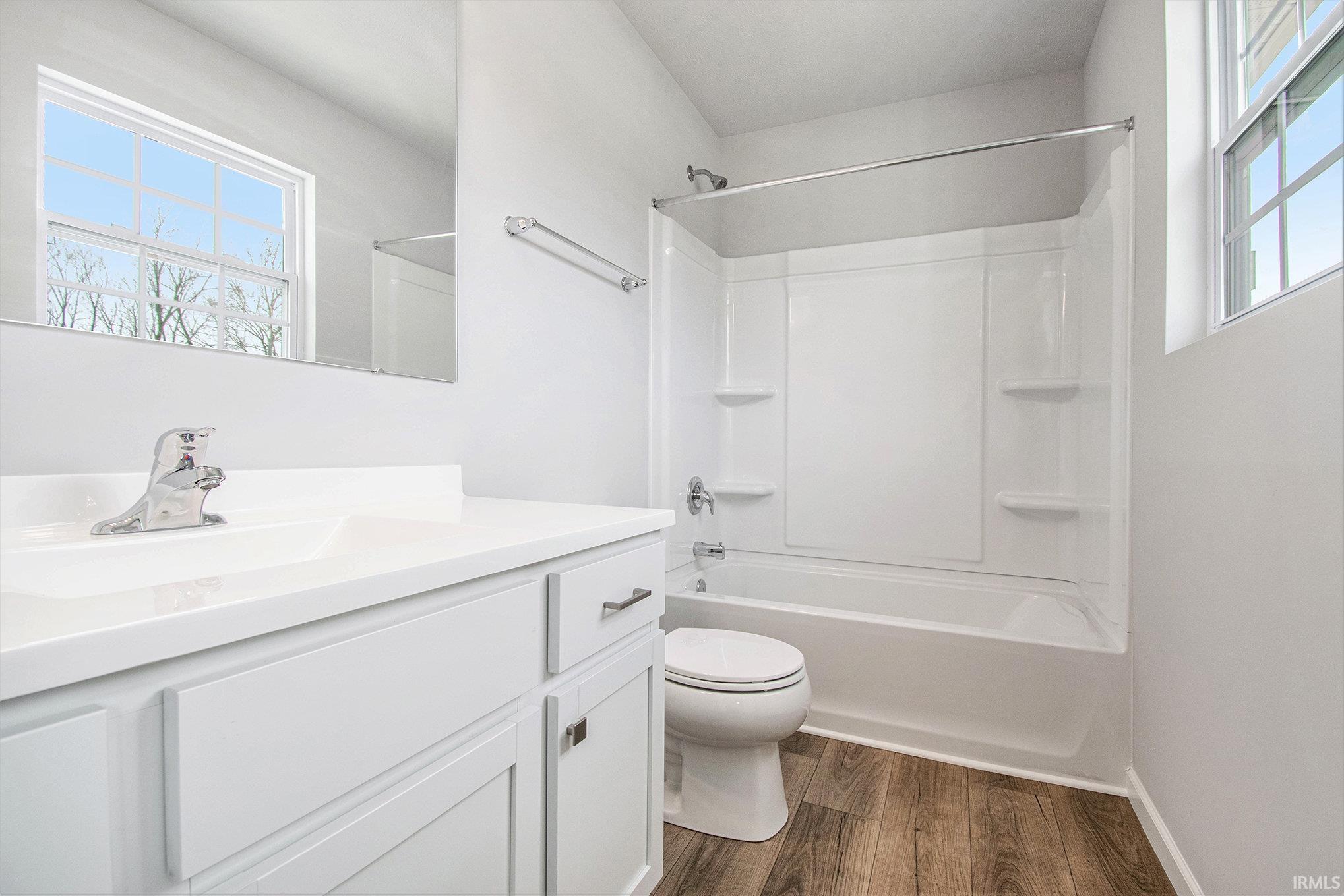 The primary suite features double exterior windows, a private bath with an exterior window and a large walk-in closet.