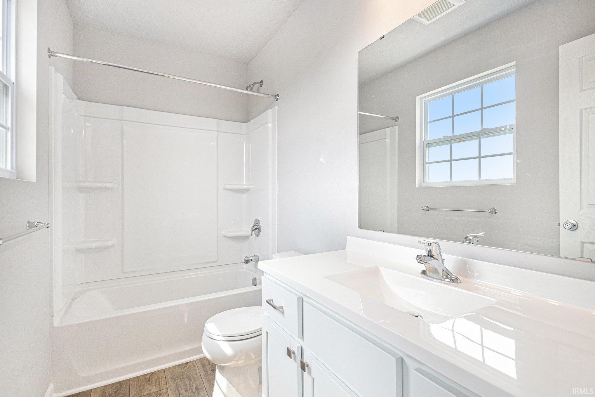 The primary suite features double exterior windows, a private bath with an exterior window and a large walk-in closet.