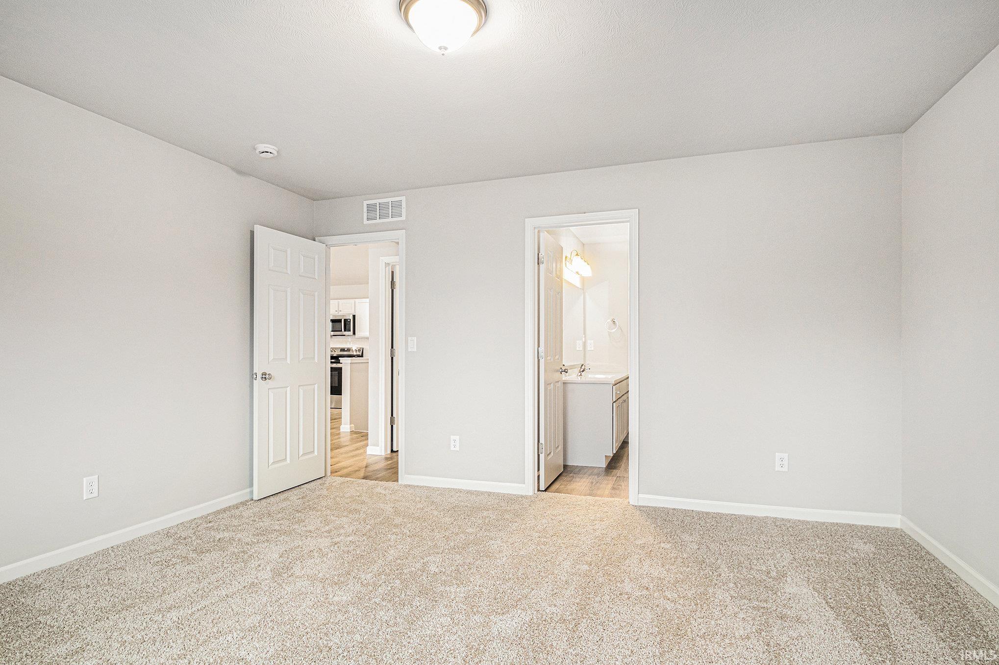 The primary suite is located on the upper level and includes a private bath and oversized walk-in closet with large window for natural lighting.