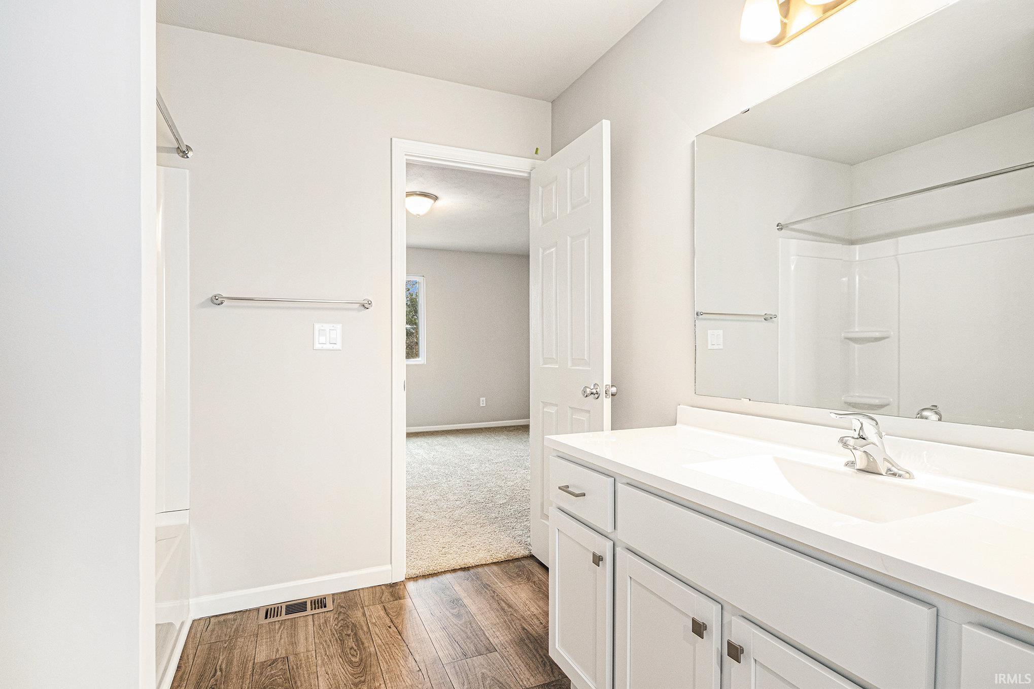 The primary suite is located on the upper level and includes a private bath and oversized walk-in closet with large window for natural lighting.