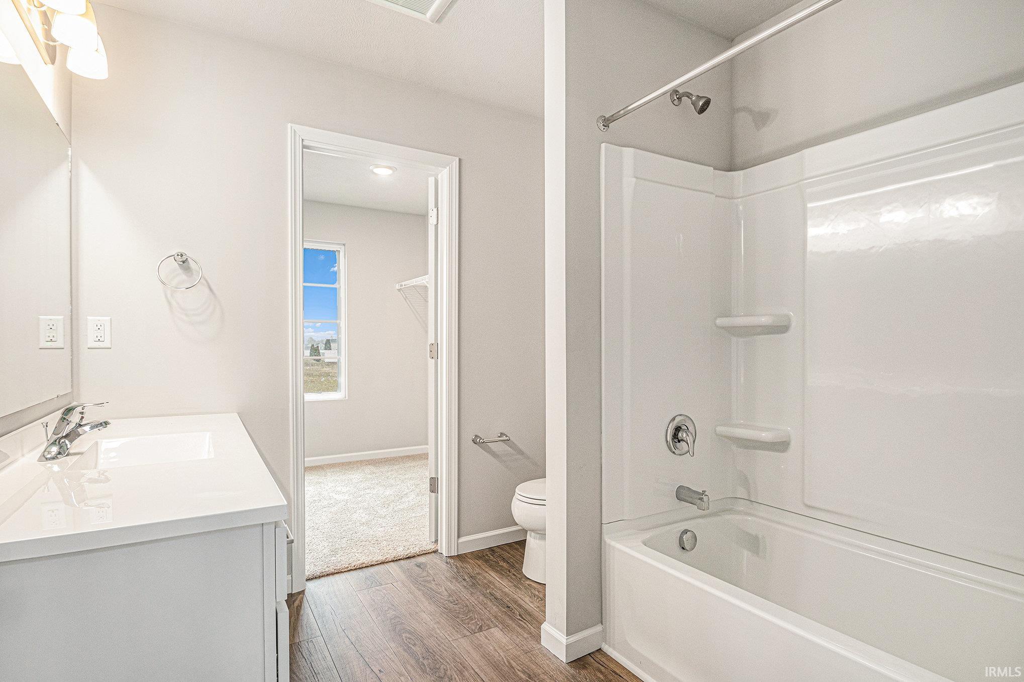 The primary suite is located on the upper level and includes a private bath and oversized walk-in closet with large window for natural lighting.