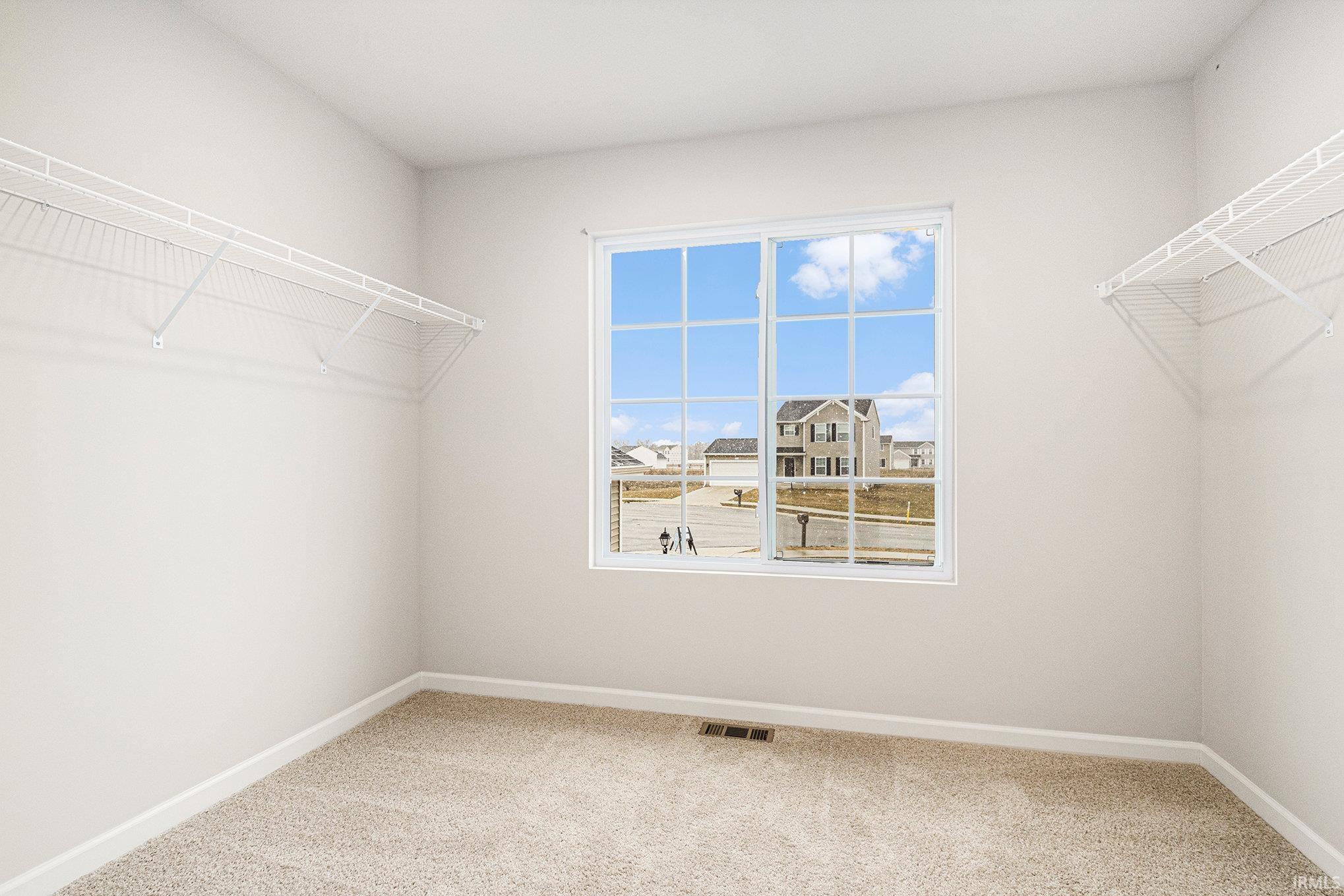 The primary suite is located on the upper level and includes a private bath and oversized walk-in closet with large window for natural lighting.