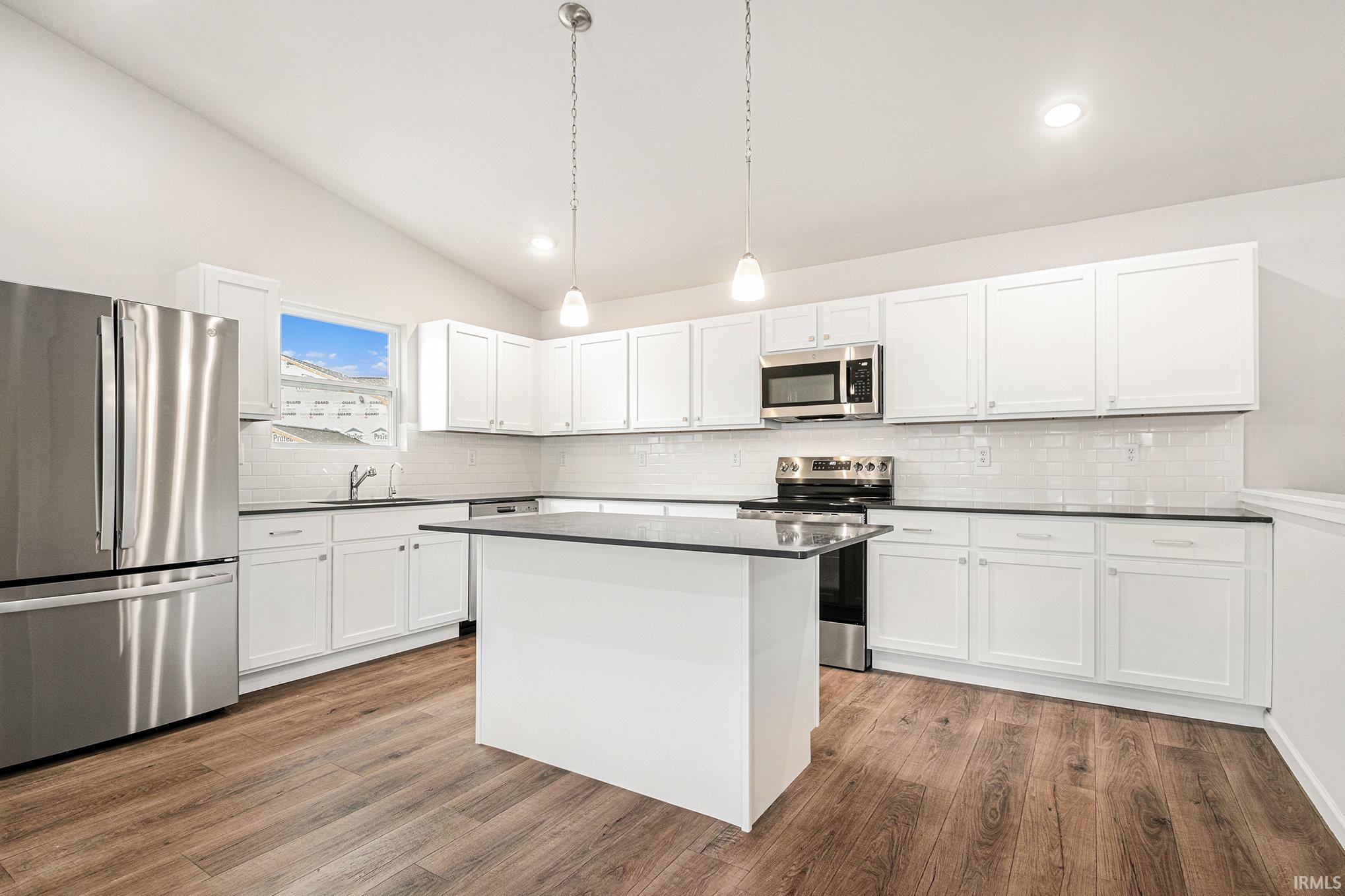 The kitchen includes Quartz counters with subway tile backsplash, large center island with extended edge counter and pendant lighting above.  Stainless steel appliances are included!