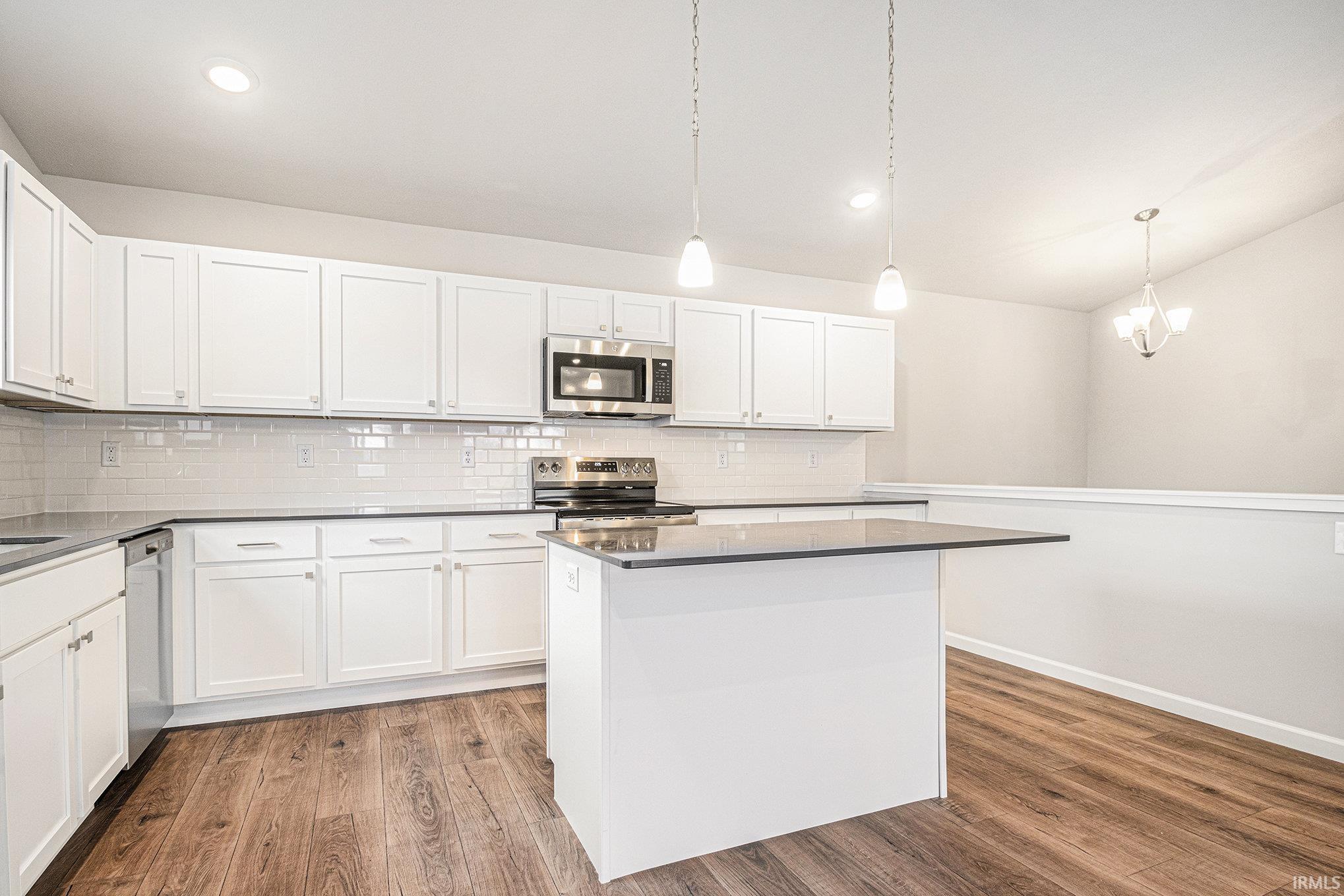 The kitchen includes Quartz counters with subway tile backsplash, large center island with extended edge counter and pendant lighting above.  Stainless steel appliances are included!