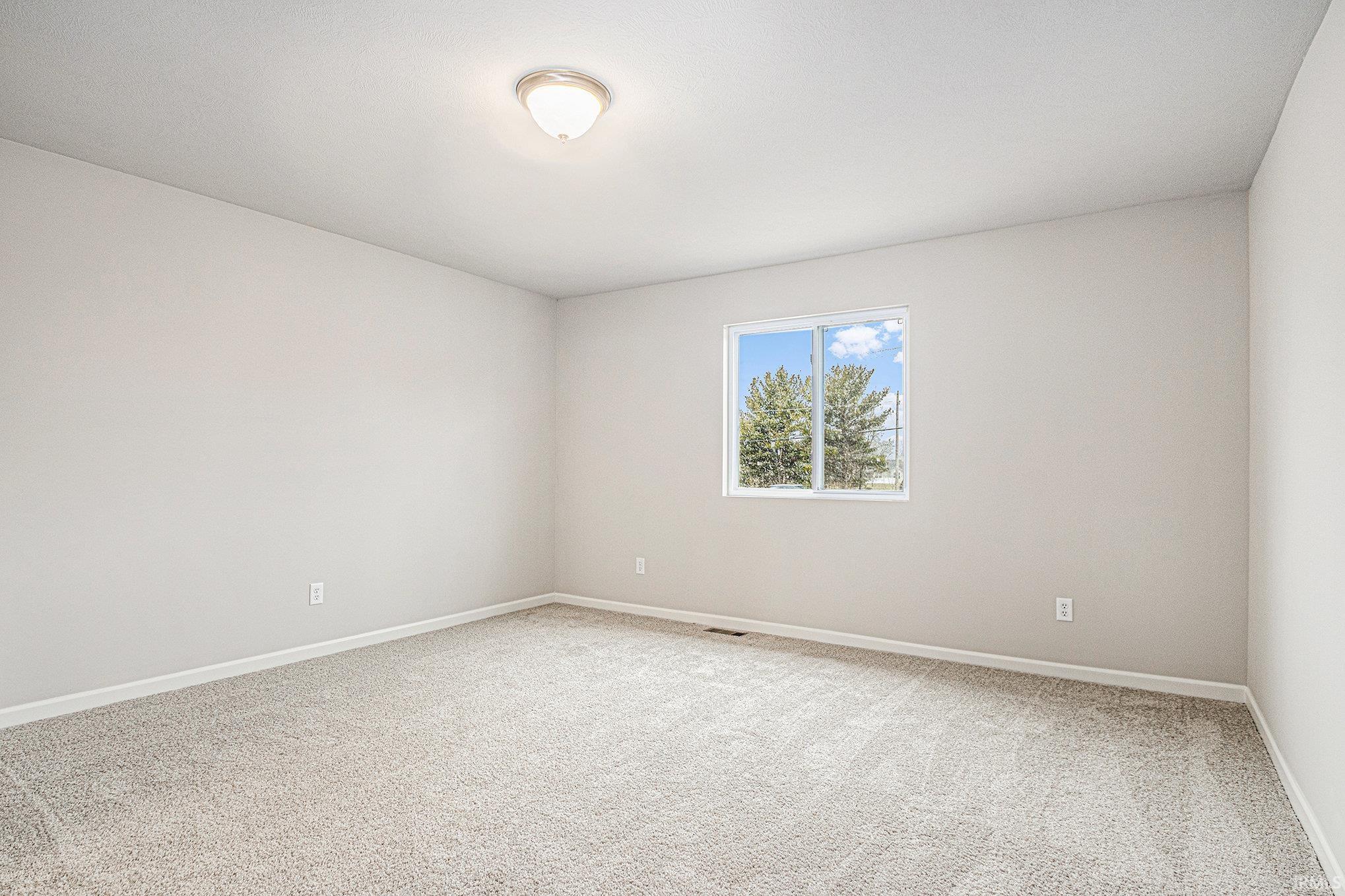 The primary suite is located on the upper level and includes a private bath and oversized walk-in closet with large window for natural lighting.