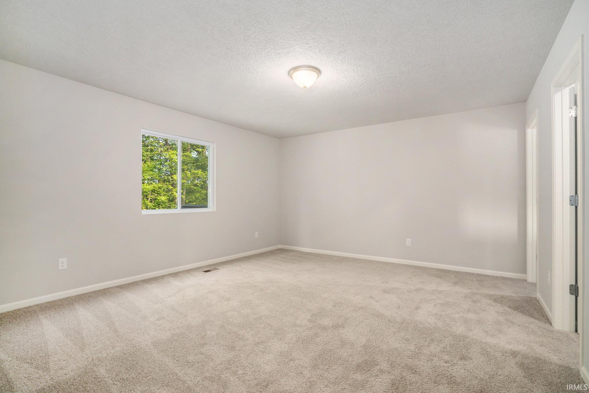 The primary suite is located on the upper level and includes a private bath and oversized walk-in closet.