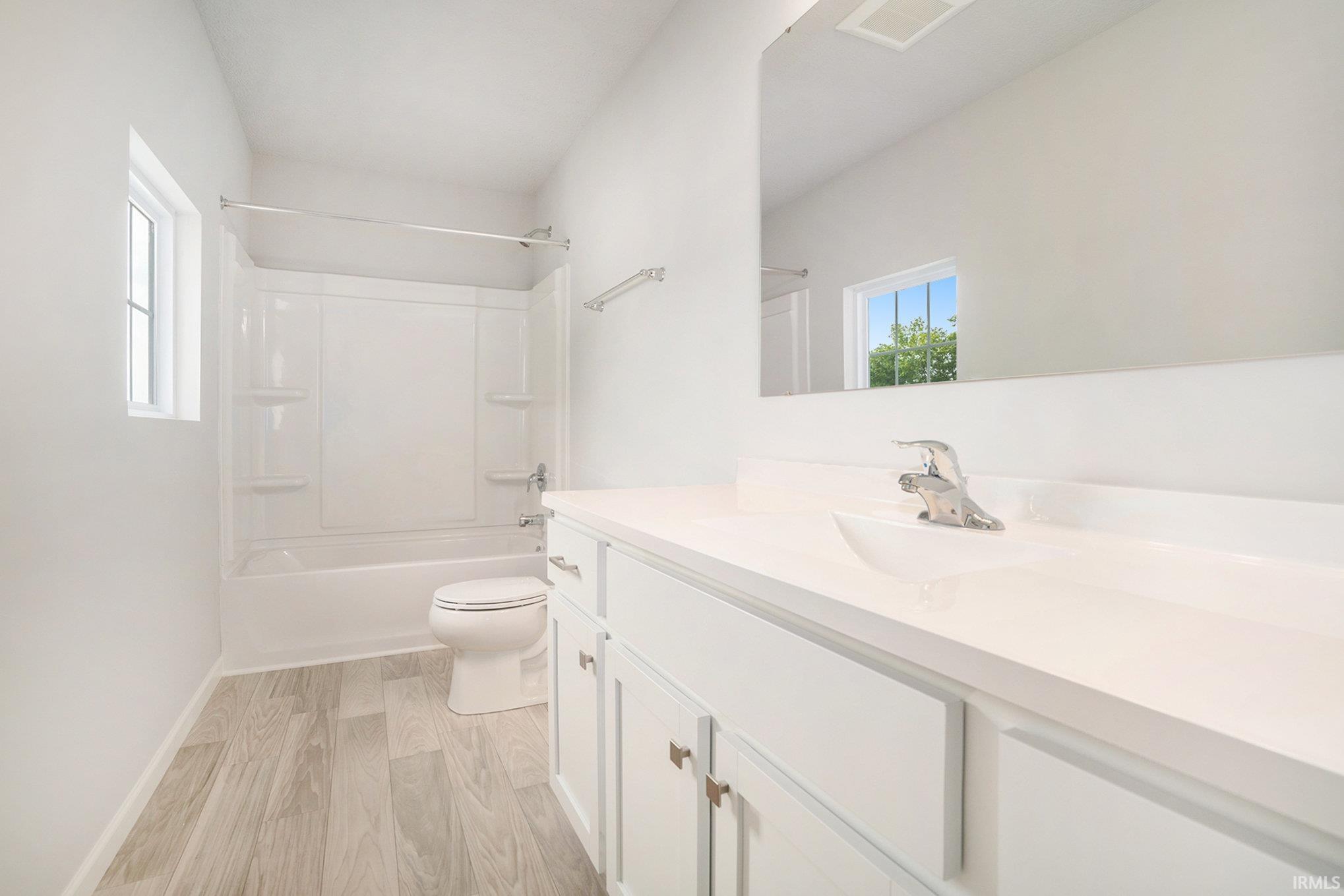 The primary suite is located on the upper level and includes a private bath and oversized walk-in closet.