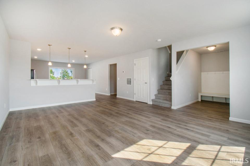 The large great room has an abundance of natural lighting and flows into a designer kitchen & nook.  Flooring is consistent throughout first floor.