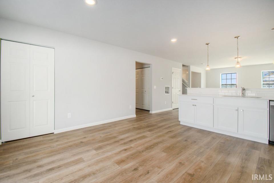 The large great room has an abundance of natural lighting and flows into a designer kitchen & nook.  Flooring is consistent throughout first floor.