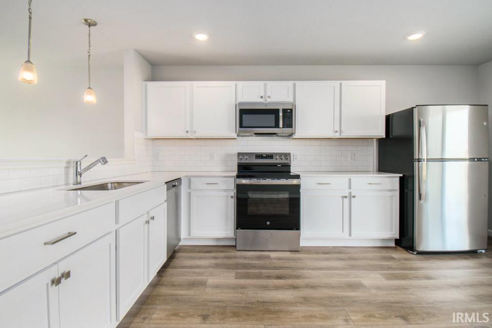 The kitchen features white cabinets and quartz counters & breakfast bar.  All appliances are included!