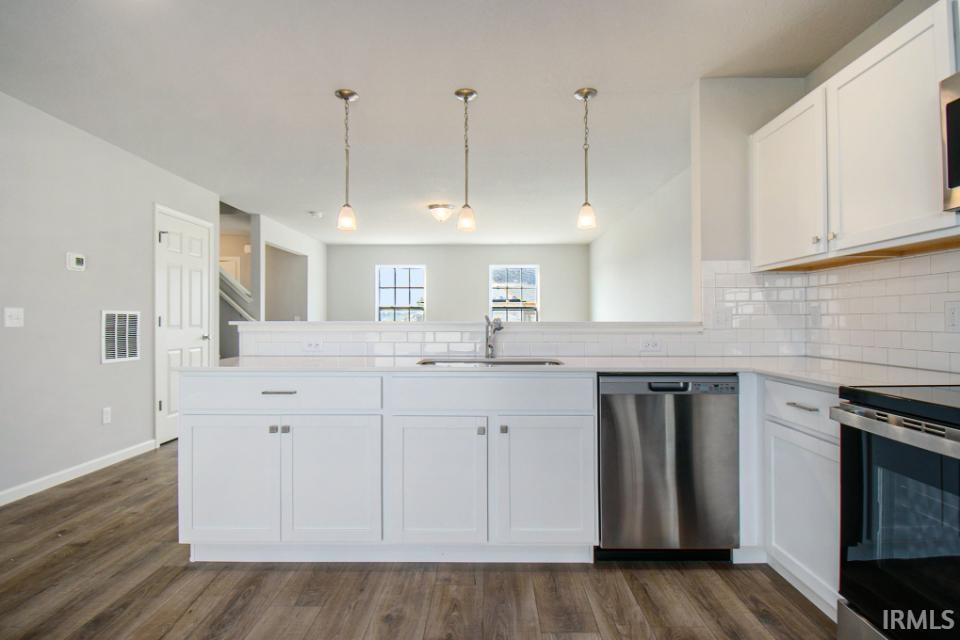 The kitchen features white cabinets and quartz counters & breakfast bar.  All appliances are included!