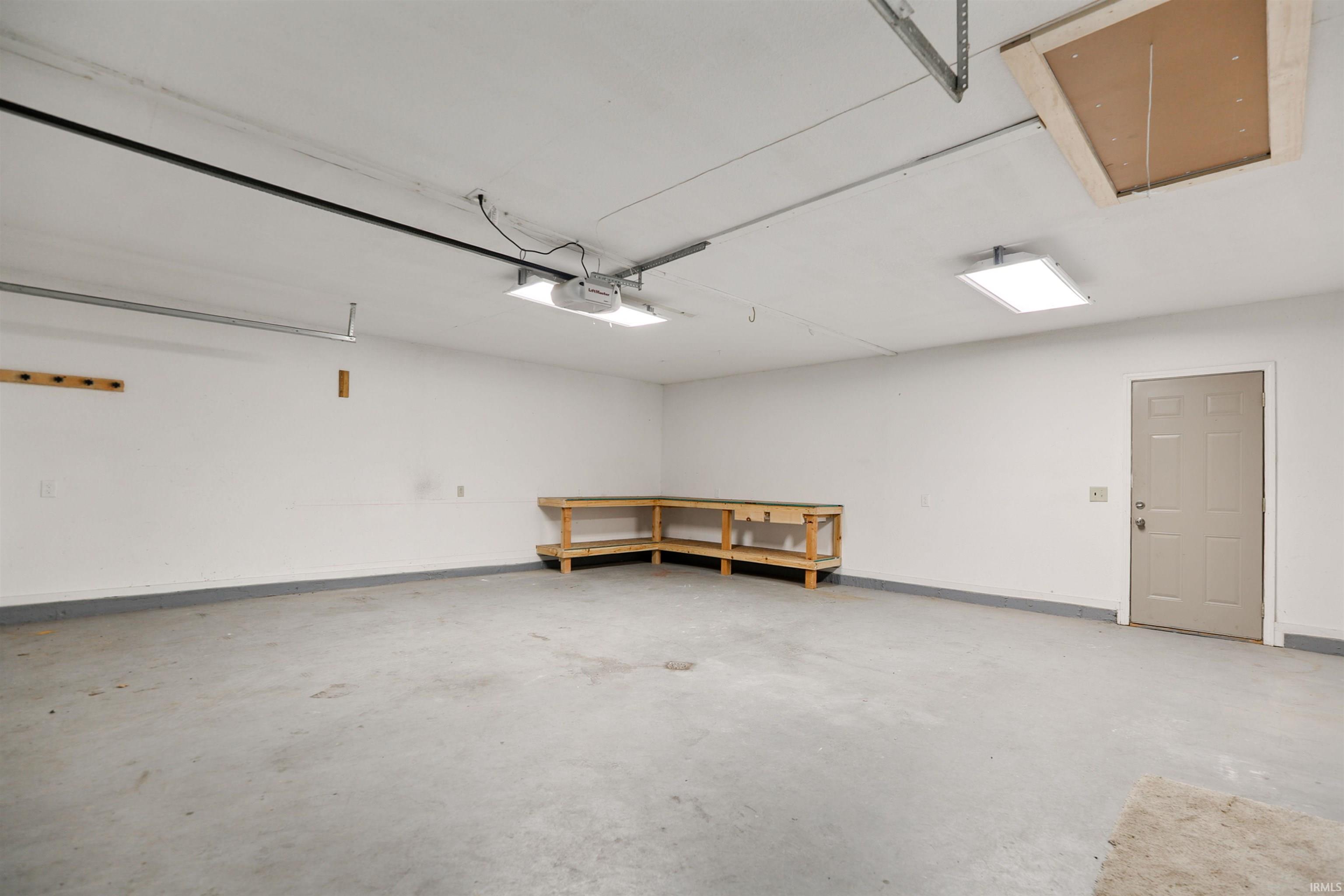 This large garage has a workbench area and expanded storage above.