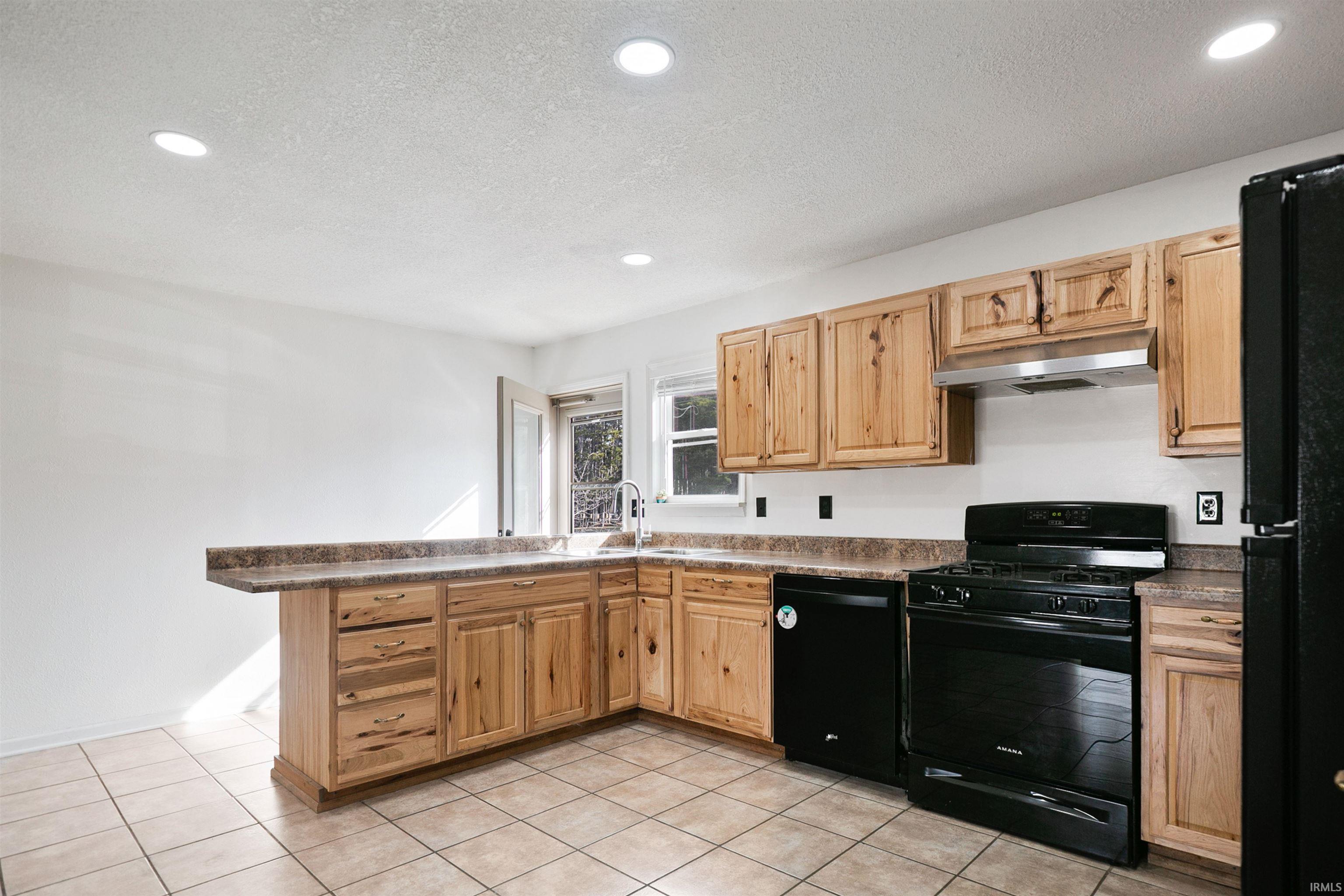 The kitchen has hickory cabinets and ceramic tile.
