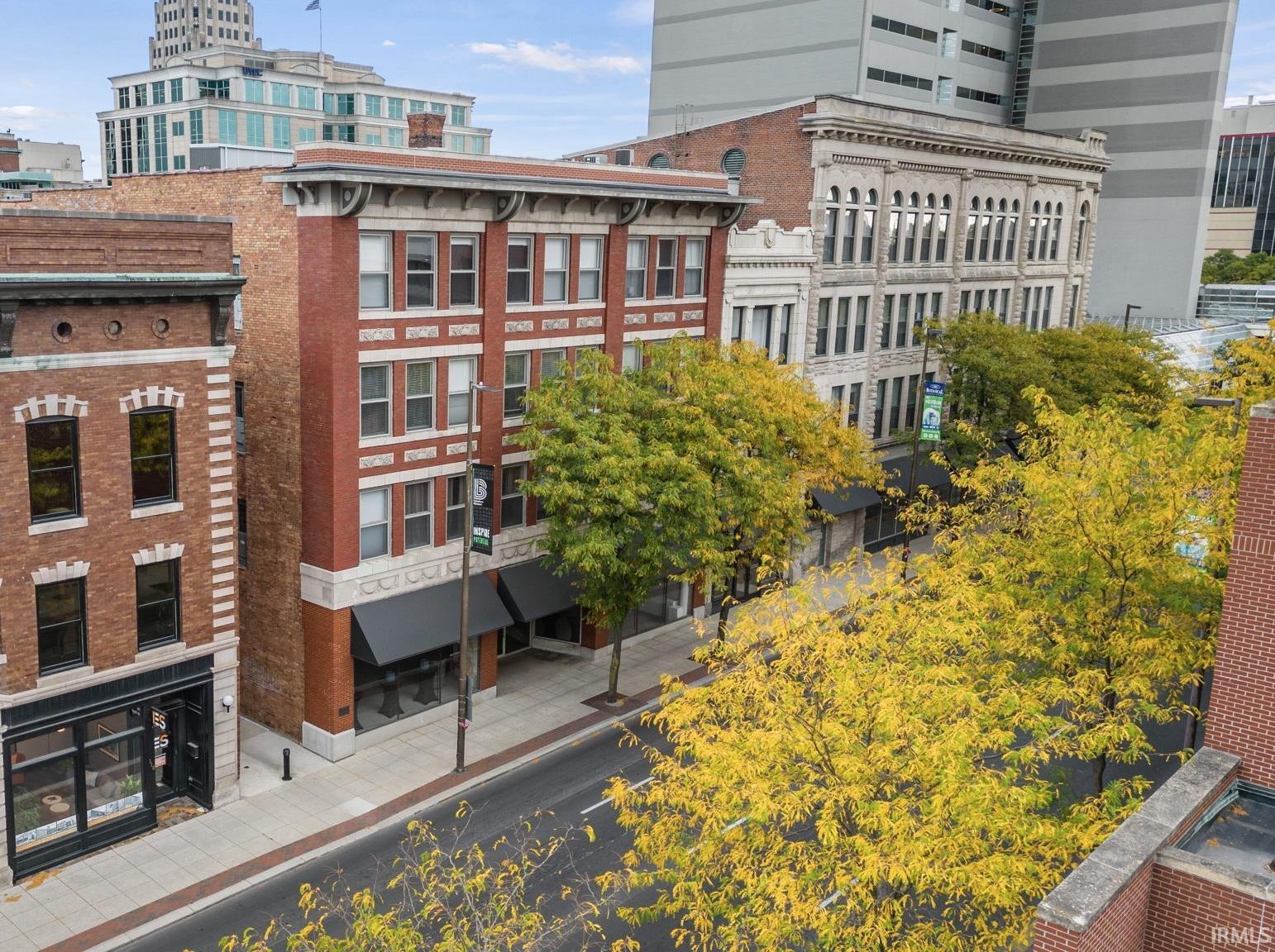 Enjoy urban living in this beautiful 4th floor condo in Midtown Crossing! The historical building is centrally located to all things downtown.  Walk to Embassy Theatre, Parkview Field, The Landing, and Promenade Park.  Enjoy fine and casual dining, and the local Art and Music scene. Inside the spacious condo offers 2 bedrooms and 2 full baths. You’ll love the vintage vibe combined with modern touches including exposed brick, engineered hardwood flooring, updated lighting, and granite countertops. The primary bedroom has an attached full bathroom and spacious closet and the second bedroom or den has a cozy electric fireplace. Amenities for the building include:  a beautiful courtyard area and raised patio, common laundry areas on each floor, two workout areas, and a secured parking garage. Parking space in secured parking garage can be transferred to new buyer for a monthly fee if desired. Along with amenities, the monthly dues also cover water, sewer, and trash. Be sure to check this one out!