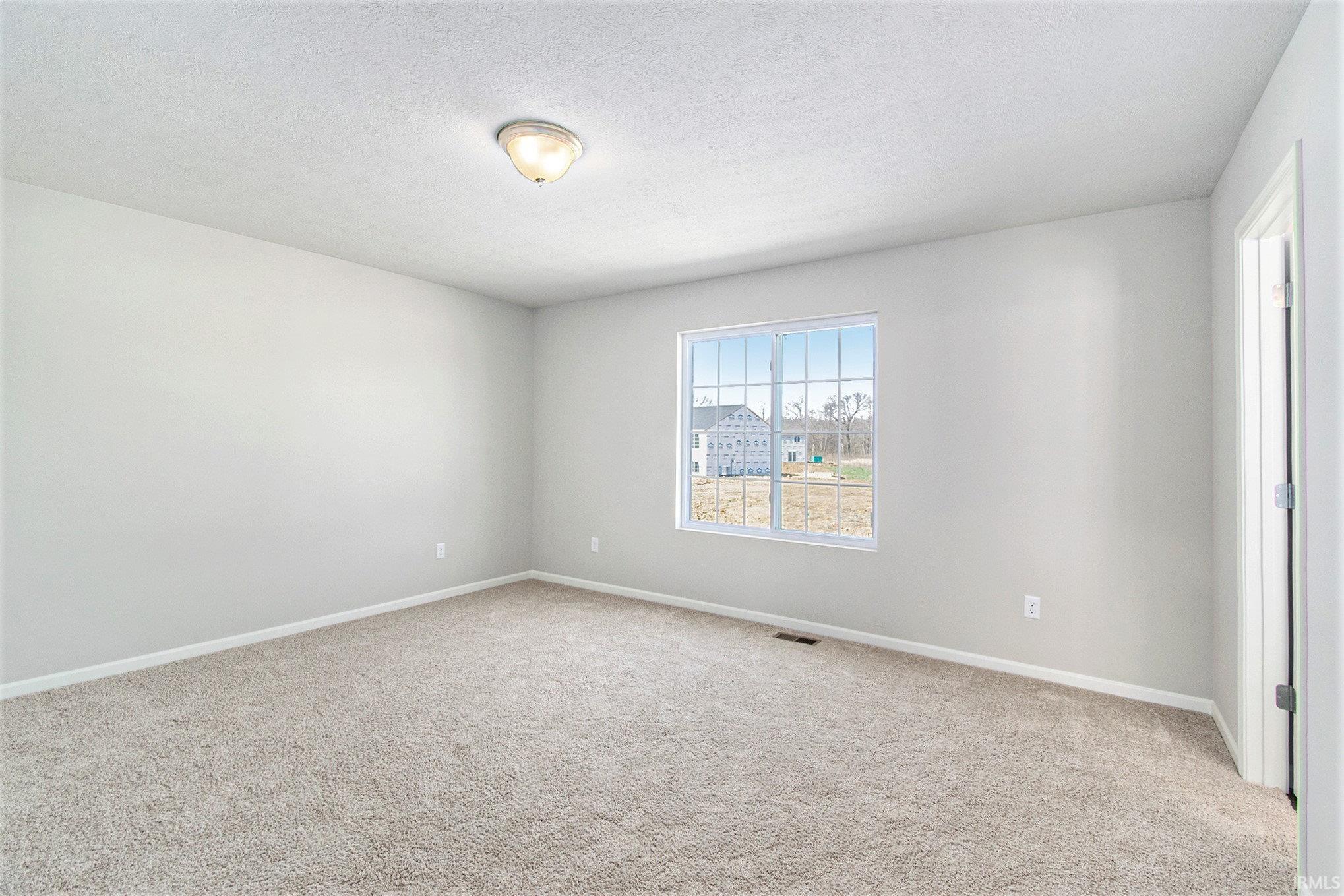 The primary suite is located on the upper level and includes a private bath with exterior window for natural lighting and a large walk-in closet.
