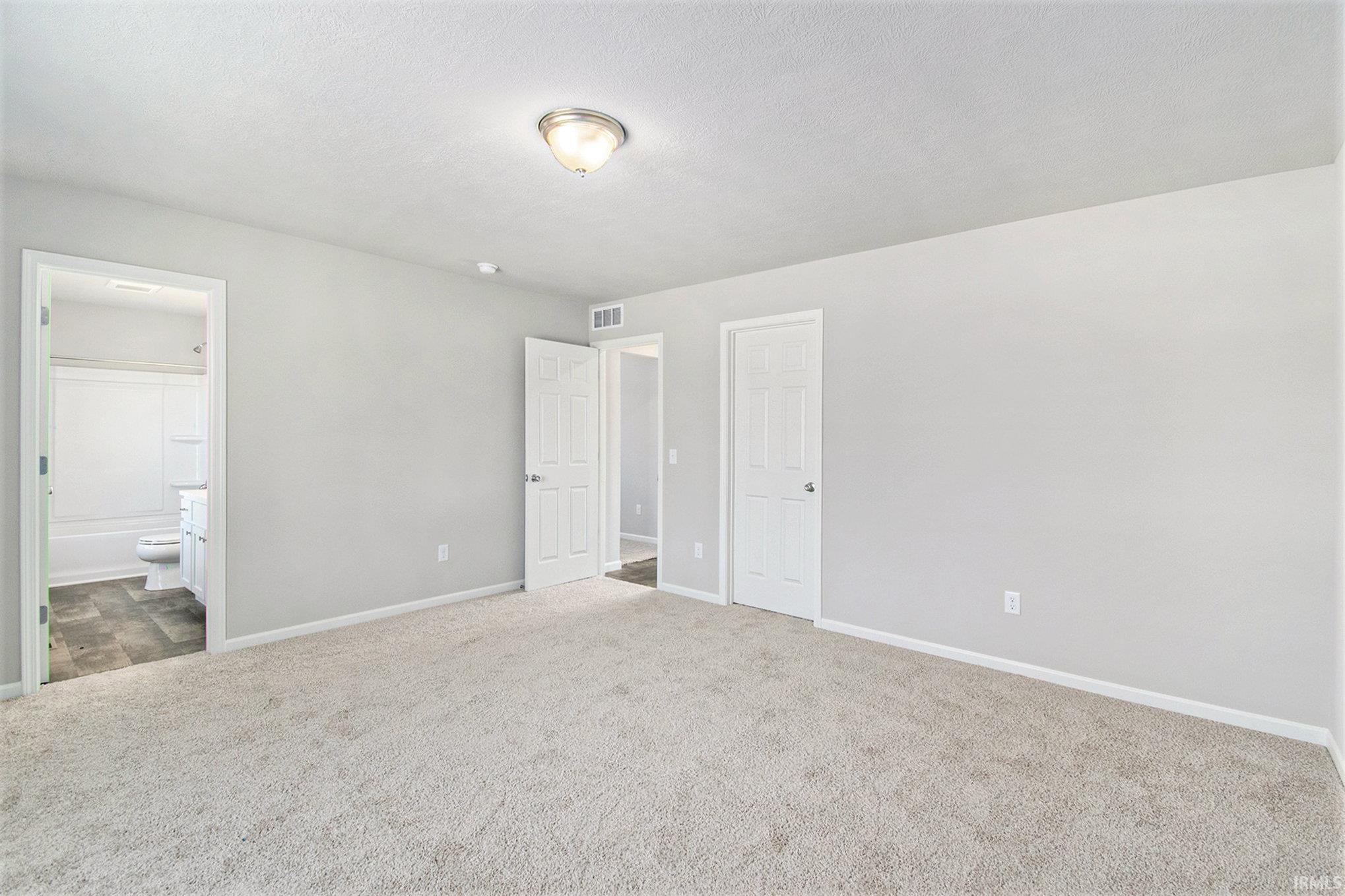 The primary suite is located on the upper level and includes a private bath with exterior window for natural lighting and a large walk-in closet.