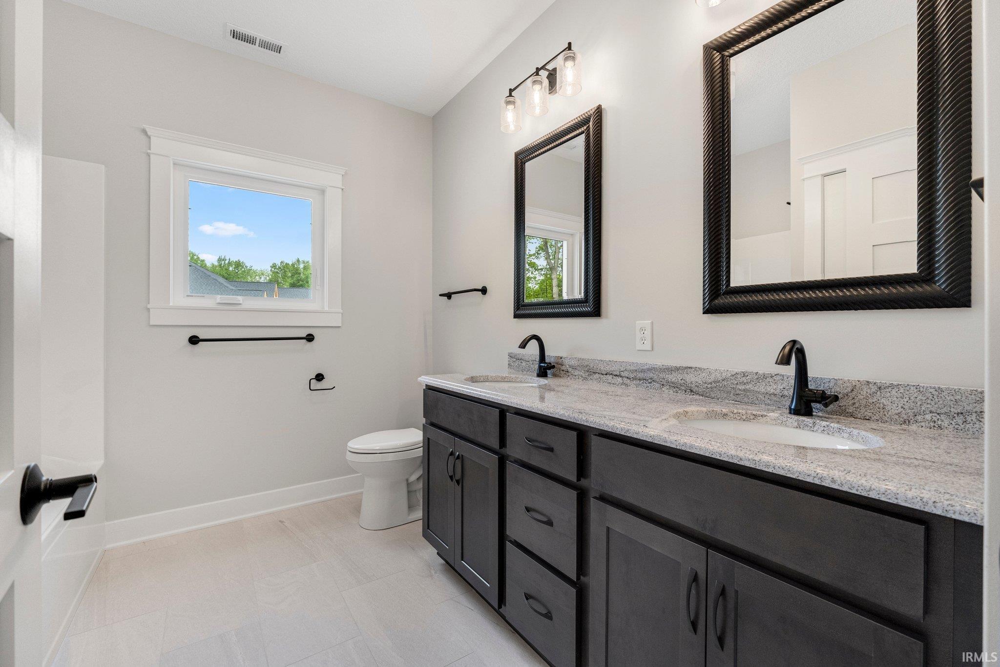 Main Hall bath w/double sinks, quartz countertops & ceramic tile flooring. 6 Ft Tub/shower combo! Linen closet w/closet concepts storage & hard-wired lighting.