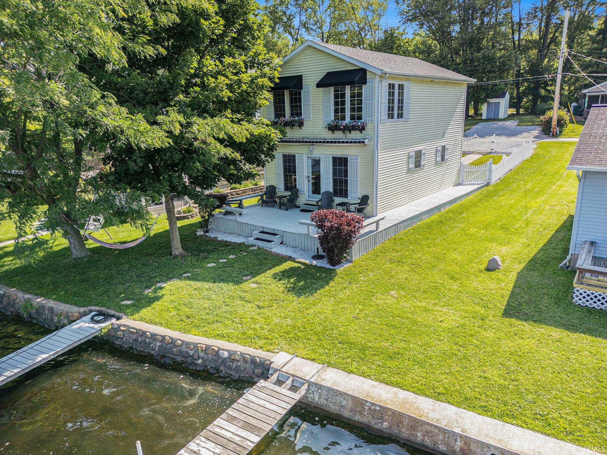 With curb appeal on both sides, this charming house is easy to spot from the lake with its awnings and window boxes.