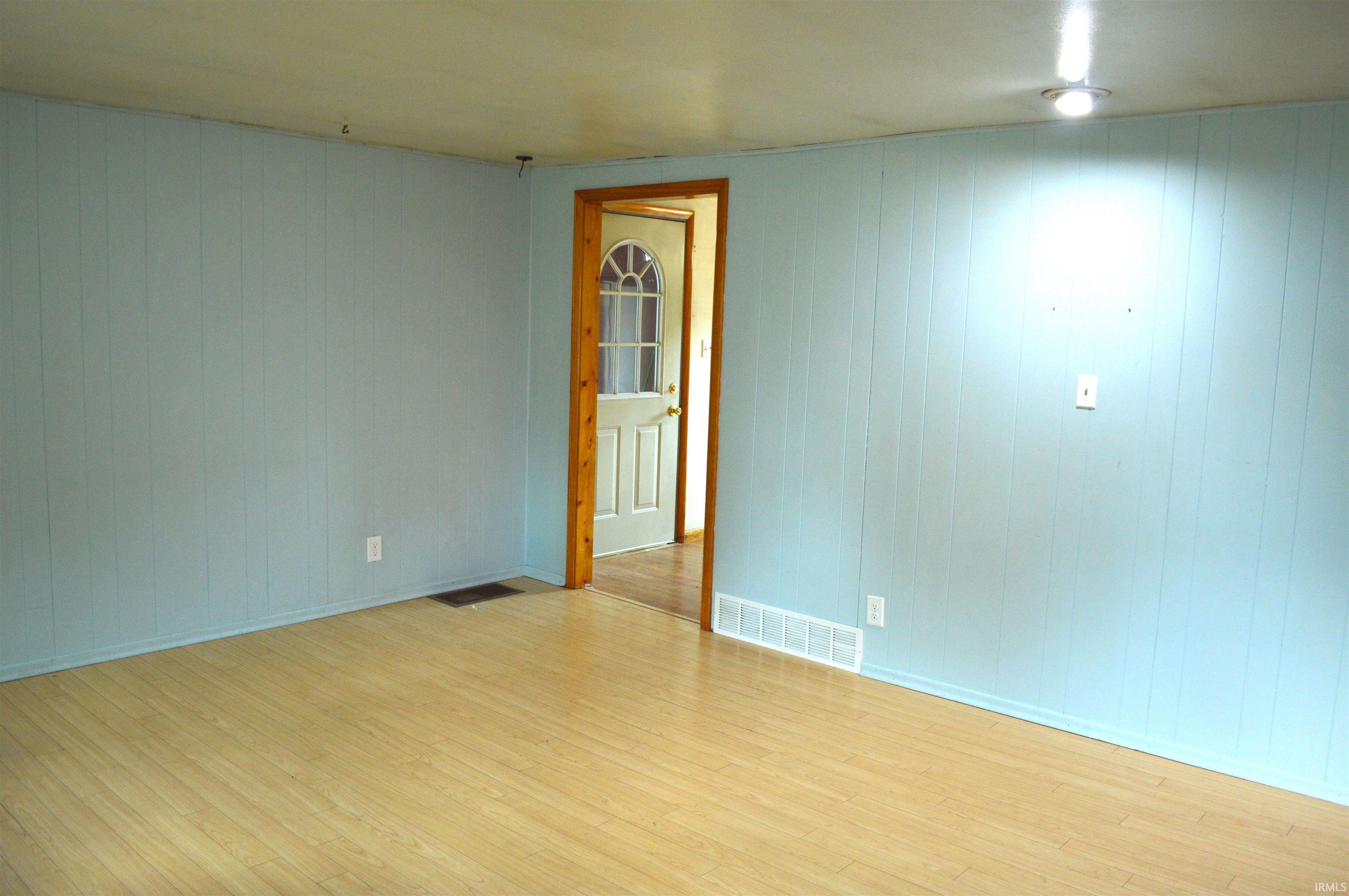 Living room from front door looking into kitchen and garage entry.