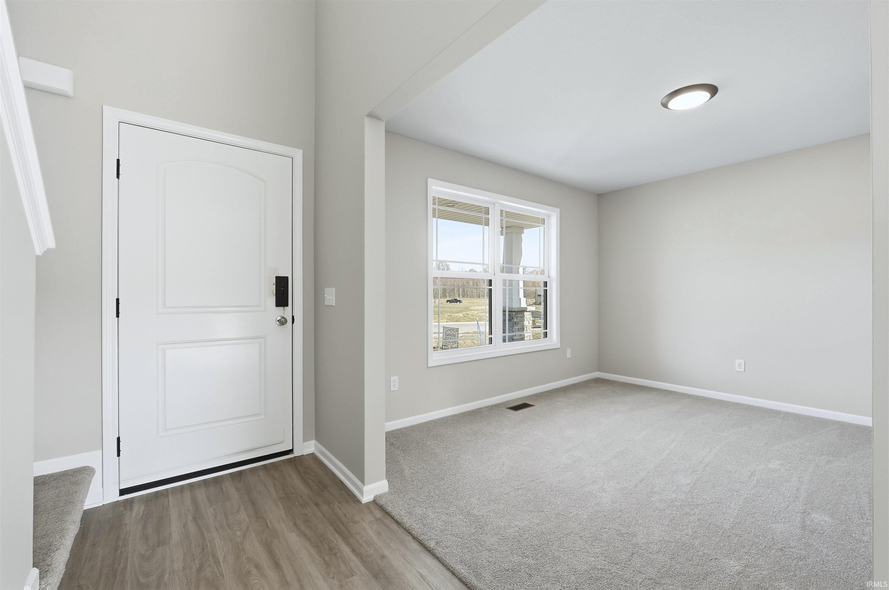 Entryway featuring light wood-style floors and light colored carpet