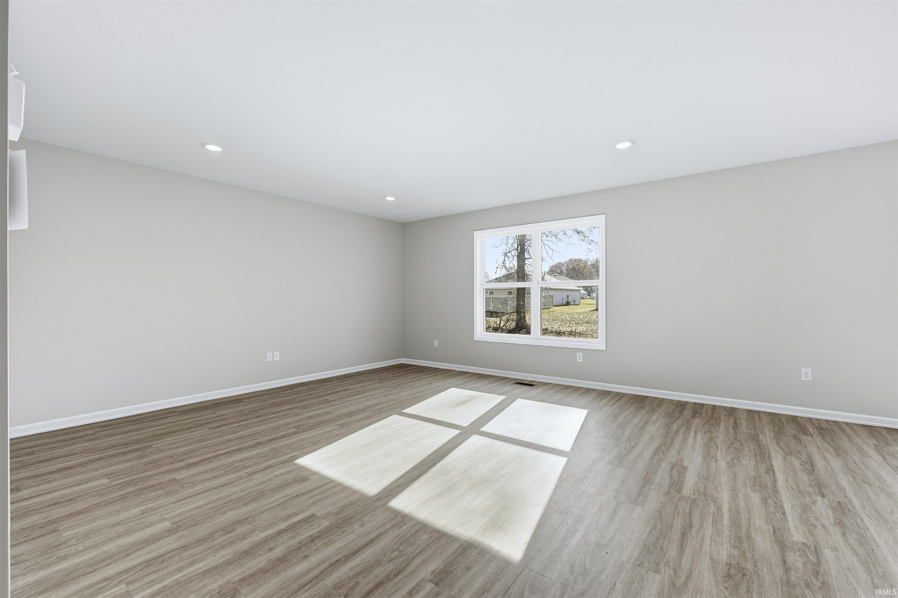 Empty room with light wood-type flooring and recessed lighting
