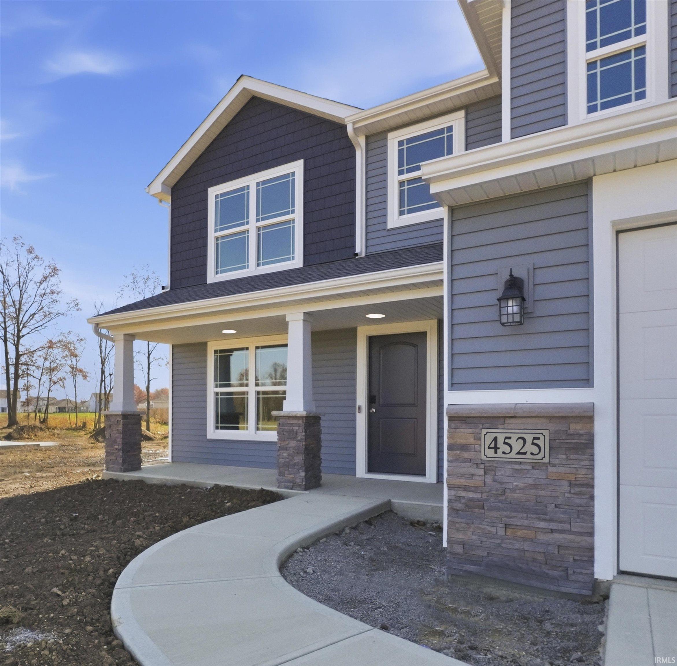 Property entrance featuring covered porch and stone siding