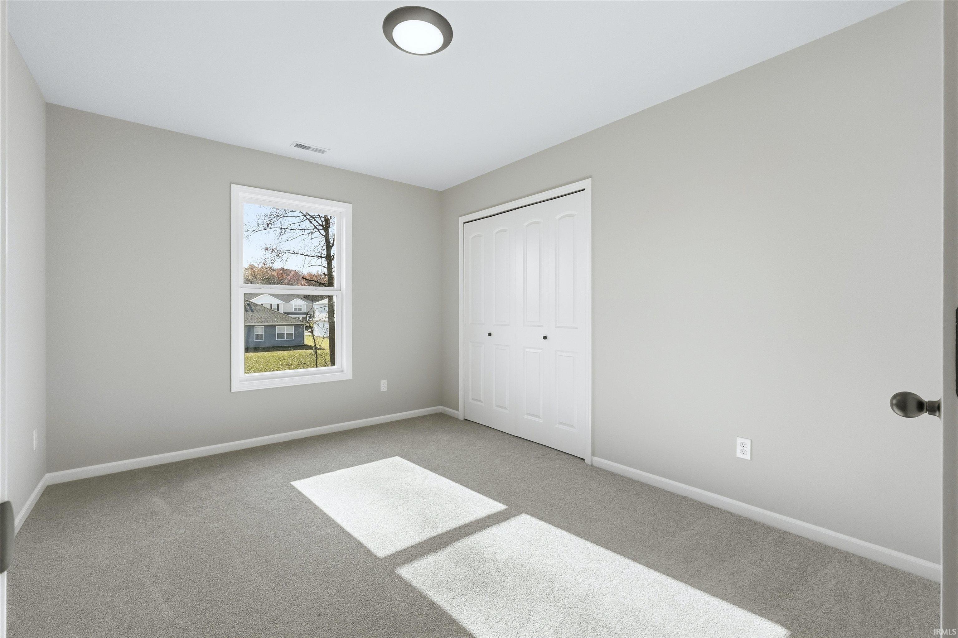 Unfurnished bedroom featuring carpet flooring and a closet