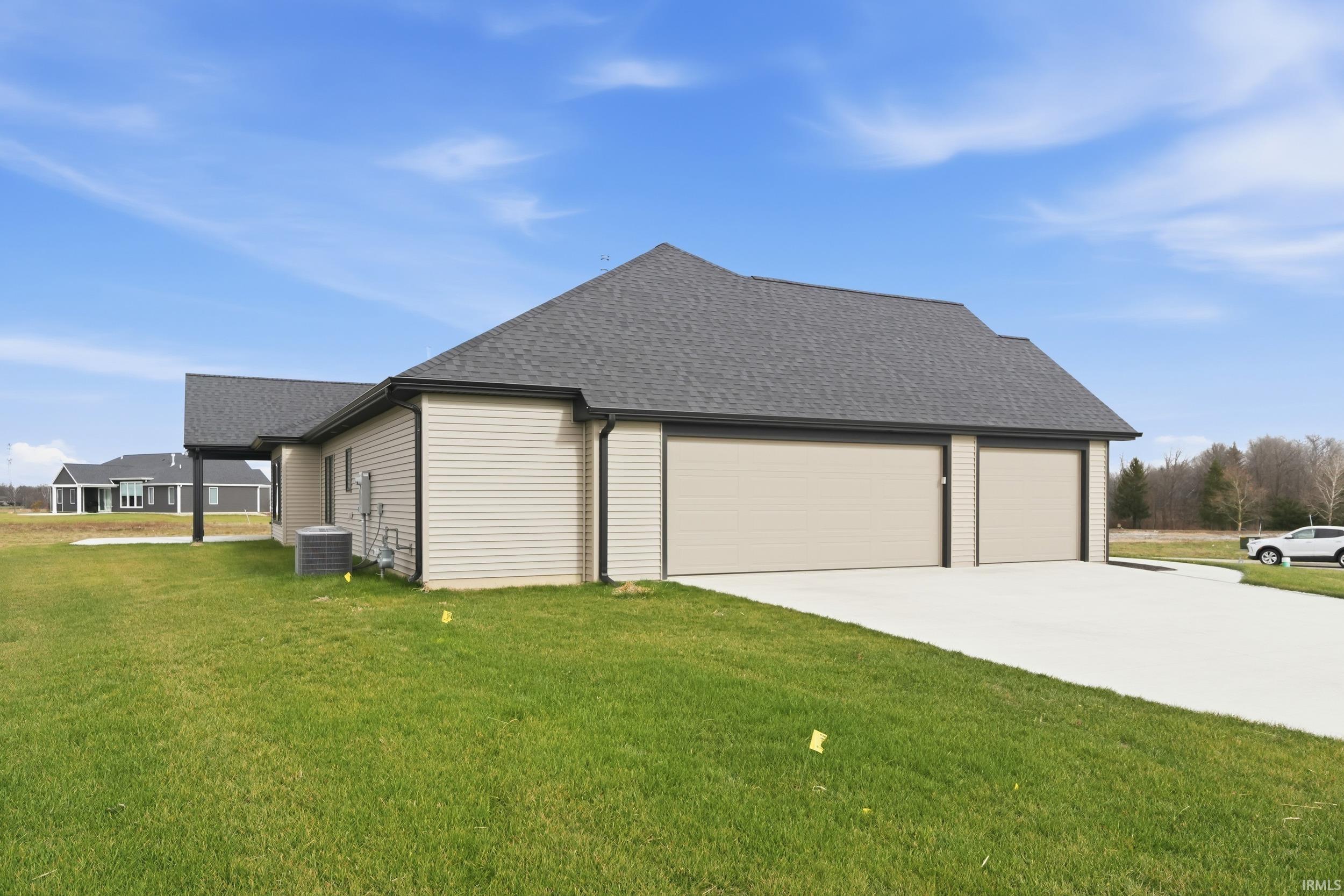 View of property exterior featuring roof with shingles, a yard, concrete driveway, and an attached garage