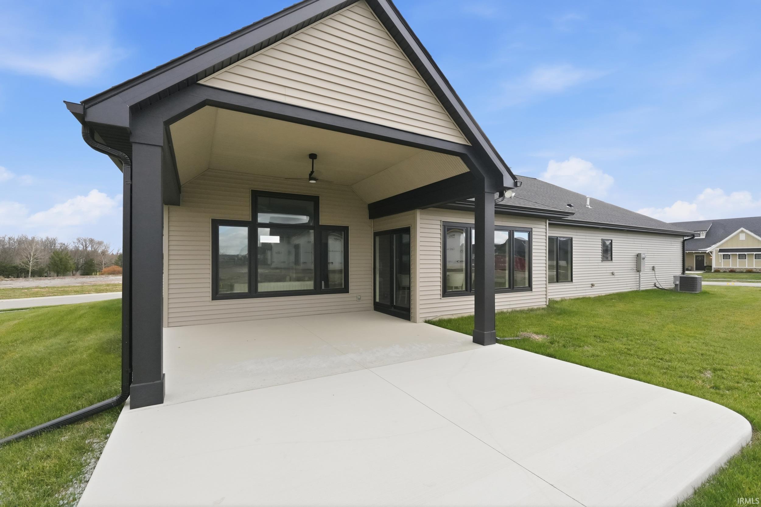 Back of house with a yard and a patio