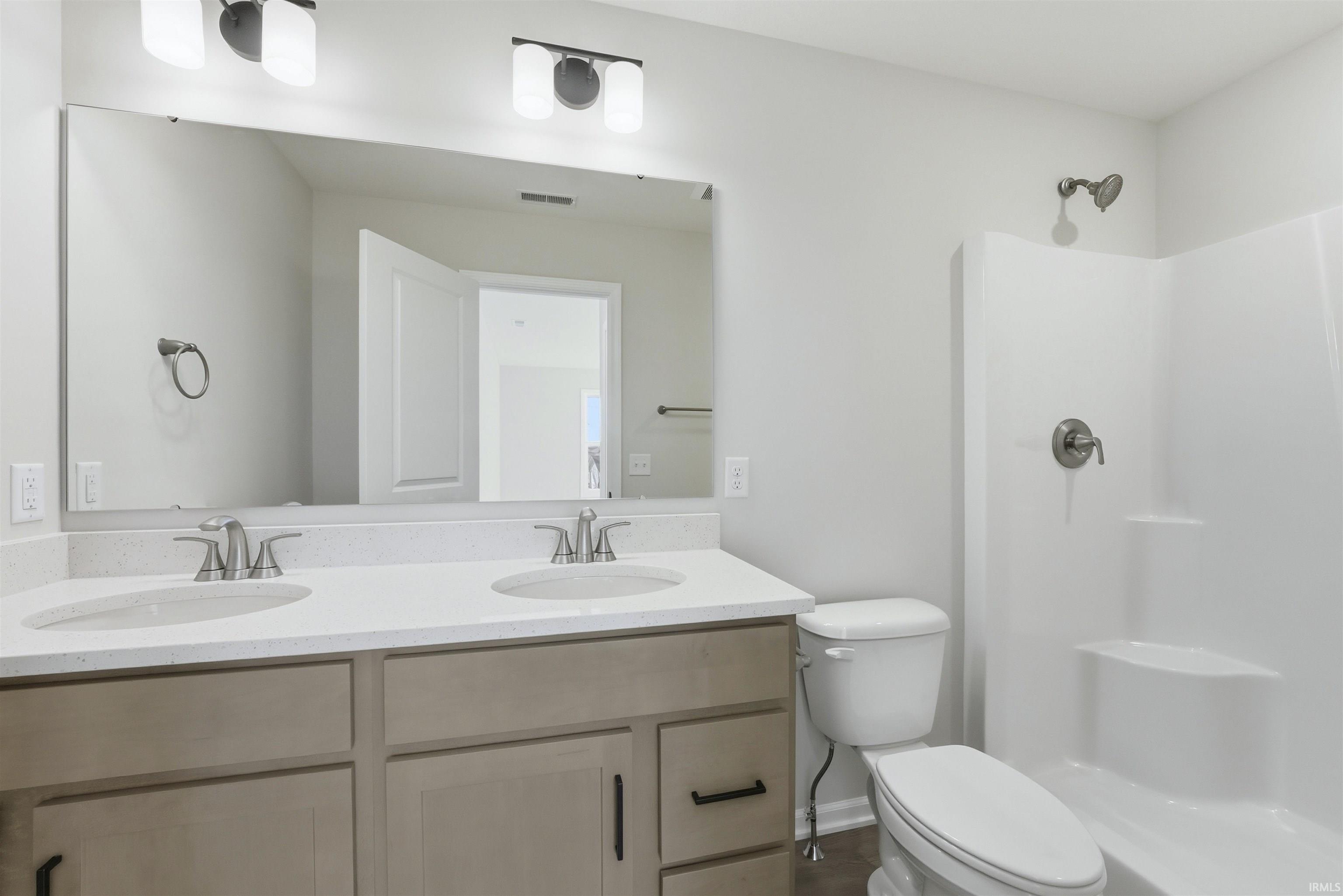Full bath featuring double vanity and a shower