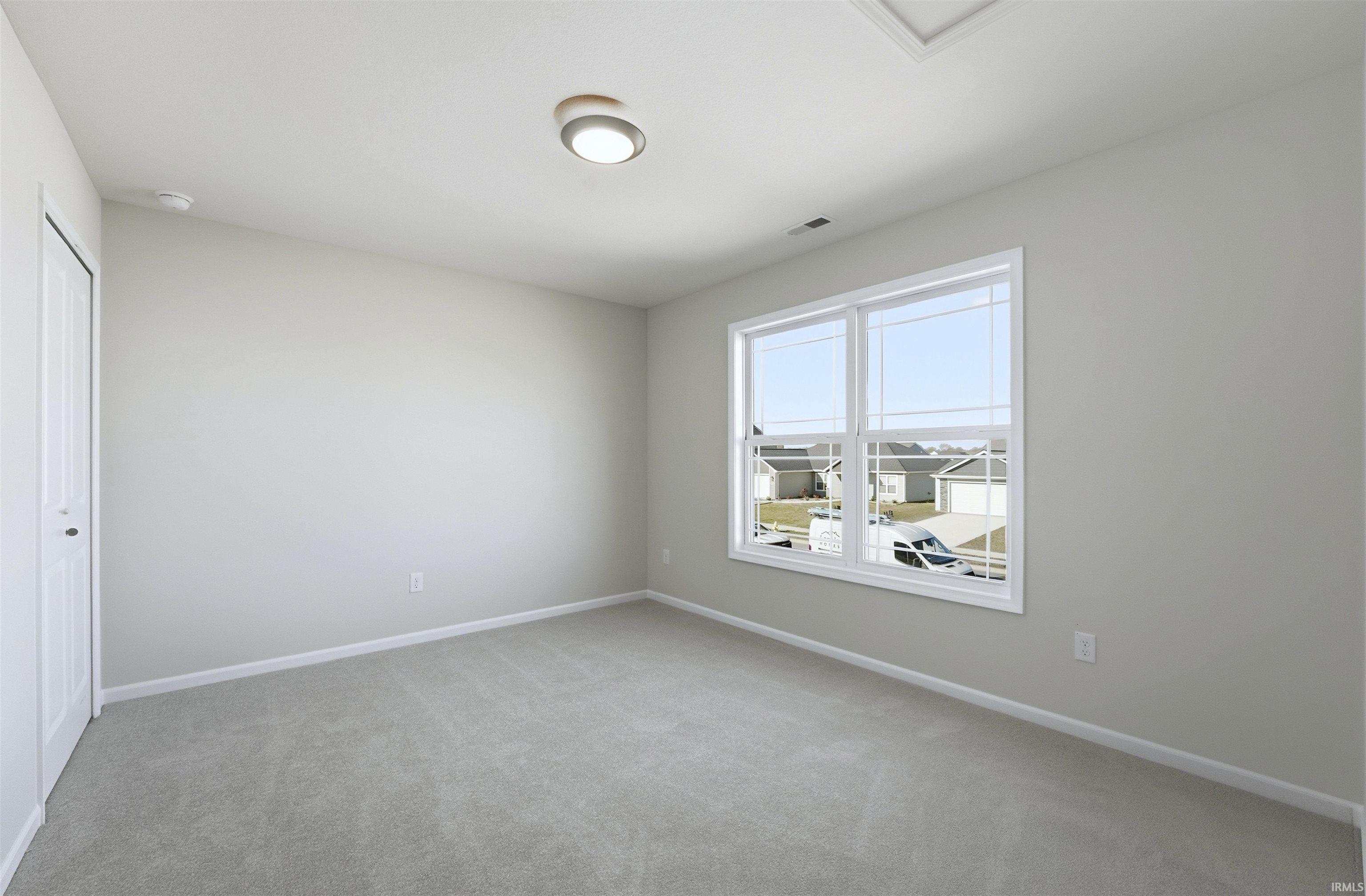 Spare room with light carpet and baseboards